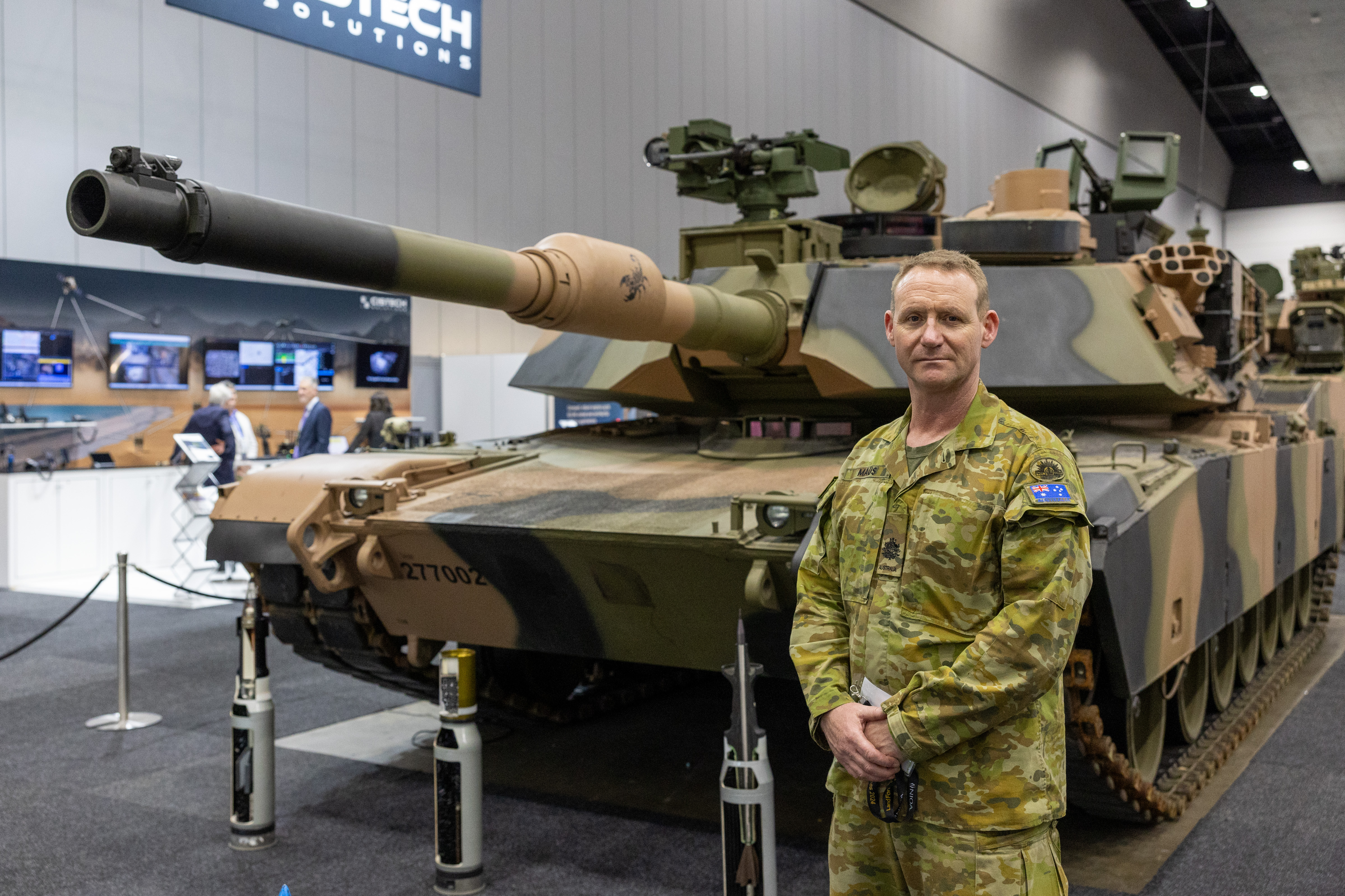 Warrant Officer Class One Bernie Maus and a M1A2 Abrams Main Battle Tank welcome attendees to the expo floor at Land Forces Melbourne 2024. *** Local Caption *** The biennial Land Forces International Land Defence Exposition is the only comprehensive international land exhibition in the region. This year was the largest exposition to date. The event is an industry-only trade exposition reserved for those with a professional, defence, governmental agency, business, academic, scientific, operational or response involvement in land domain, defence related government and industry sectors.