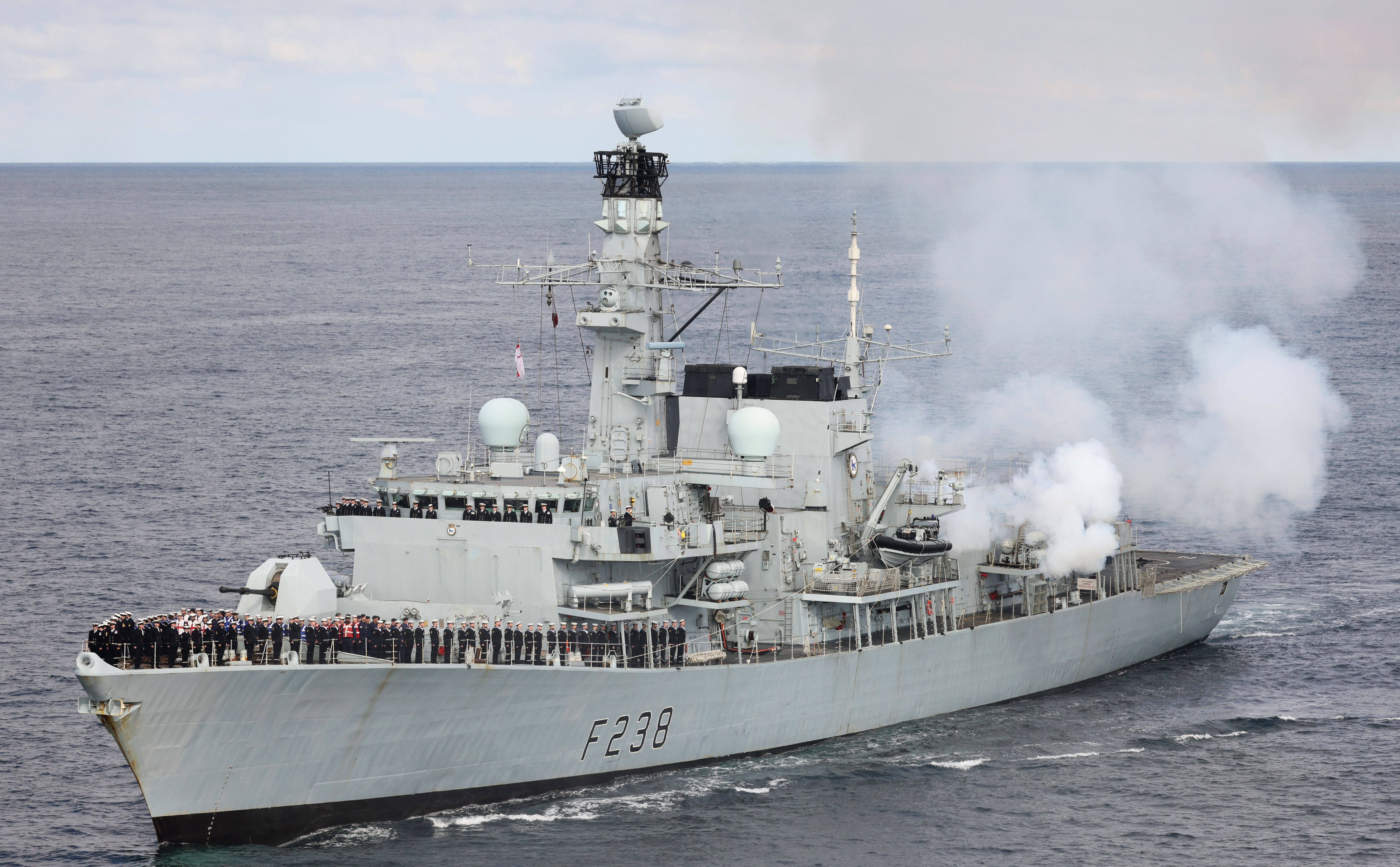 Image of HMS Northumberland at sea, with the crew on deck paying their respect to Her Majesty Queen Elizabeth II.