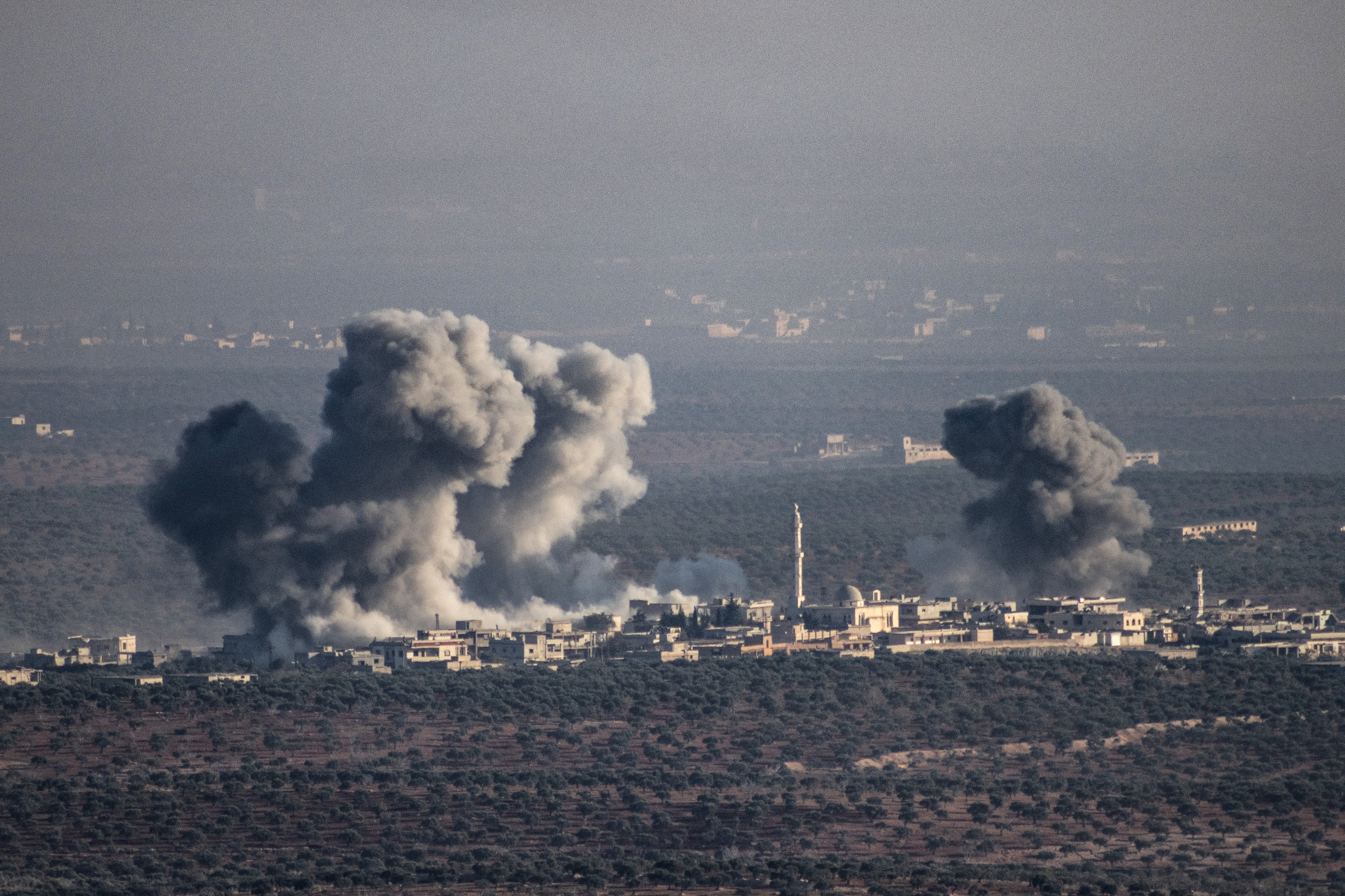 28 November 2024, Syria, Majdalya: Smoke rises as a result of a Syrian regime airstrike targeting the town of Majdalya in the Idlib countryside. Photo: Anas Alkharboutli/dpa (Photo by Anas Alkharboutli/picture alliance via Getty Images)