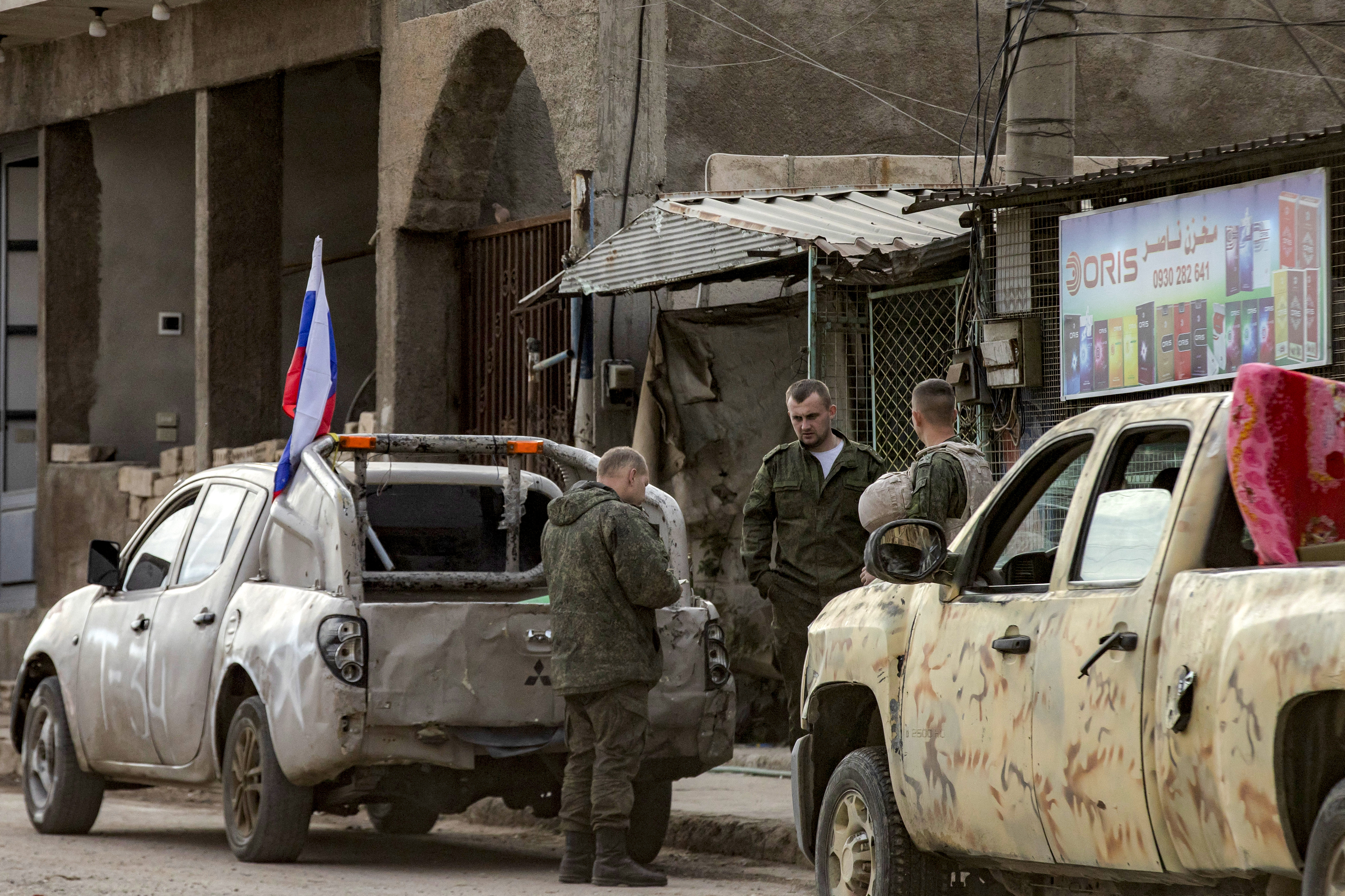 TOPSHOT - Russian soldiers stand by military pickups as they prepare to evacuate a position in Qamishli in northeastern Syria on December 12, 2024. Islamist-led rebels took the Syrian capital Damascus in a lightning offensive on December 8, ousting president Bashar al-Assad and ending five decades of Baath rule in the country. Assad was propped up by Russia, where he reportedly fled, as well as Iran and Lebanon's Hezbollah militant group. (Photo by Delil SOULEIMAN / AFP) (Photo by DELIL SOULEIMAN/AFP via Getty Images)