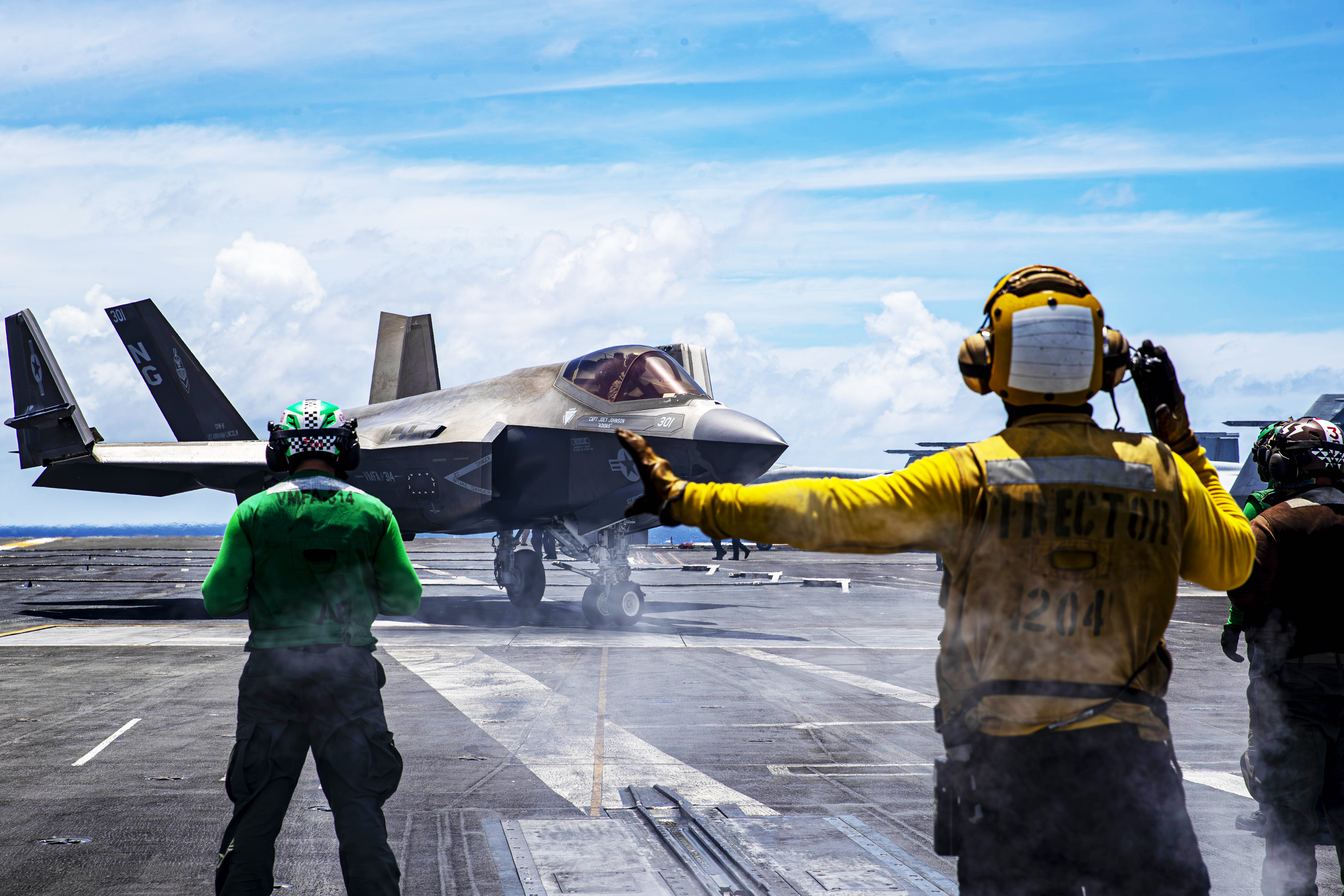 240730-N-NH911-1123 PACIFIC OCEAN (July 30, 2024) Aviation Boatswain’s Mate (Handling) 2nd Class Mark Baldovino, from Illocos Sur, Philippines, directs an F-35C Lightning II, assigned to Marine Fighter Attack Squadron (VMFA) 314, on the flight deck of the Nimitz-class aircraft carrier USS Abraham Lincoln (CVN 72). Abraham Lincoln, flagship of Carrier Strike Group Three, is underway conducting routine operations in the U.S. 7th Fleet area of operations. U.S. 7th Fleet is the U.S. Navy’s largest forward-deployed numbered fleet, and routinely interacts and operates with allies and partners in preserving a free and open Indo-Pacific region. (U.S. Navy photo by Mass Communication Specialist Seaman Apprentice Daniel Kimmelman)
