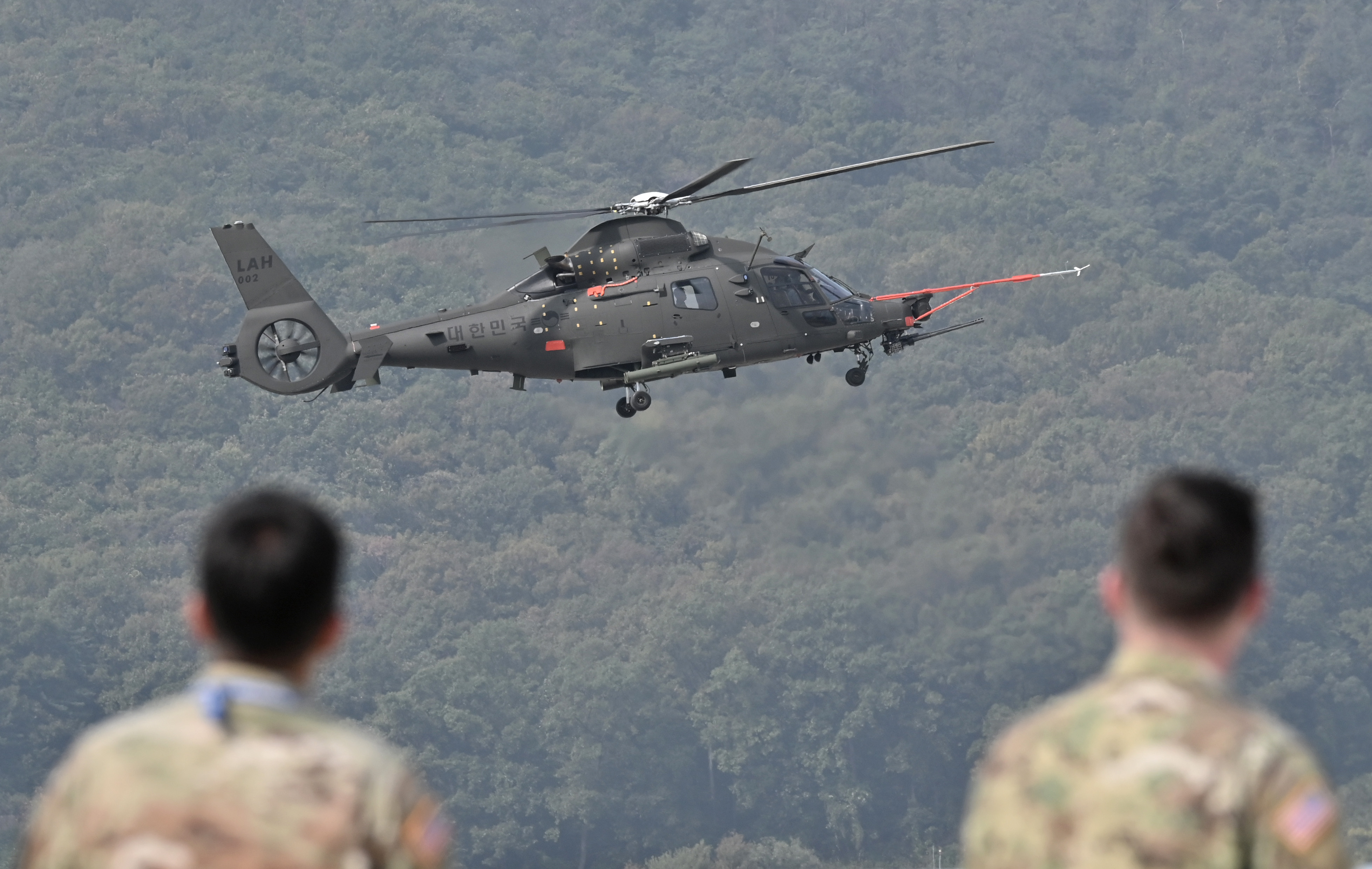 US soldiers look at a performance of a KAI Light Armed Helicopter (LAH) developed by Korea Aerospace Industries (KAI) for the South Korean Army, during a preview of the Seoul International Aerospace and Defense Exhibition at a military air base in Seongnam, south of Seoul, on October 14, 2019. - The exhibition will run from October 15 to 20 with 430 companies from 34 countries taking part. (Photo by Jung Yeon-je / AFP) (Photo by JUNG YEON-JE/AFP via Getty Images)