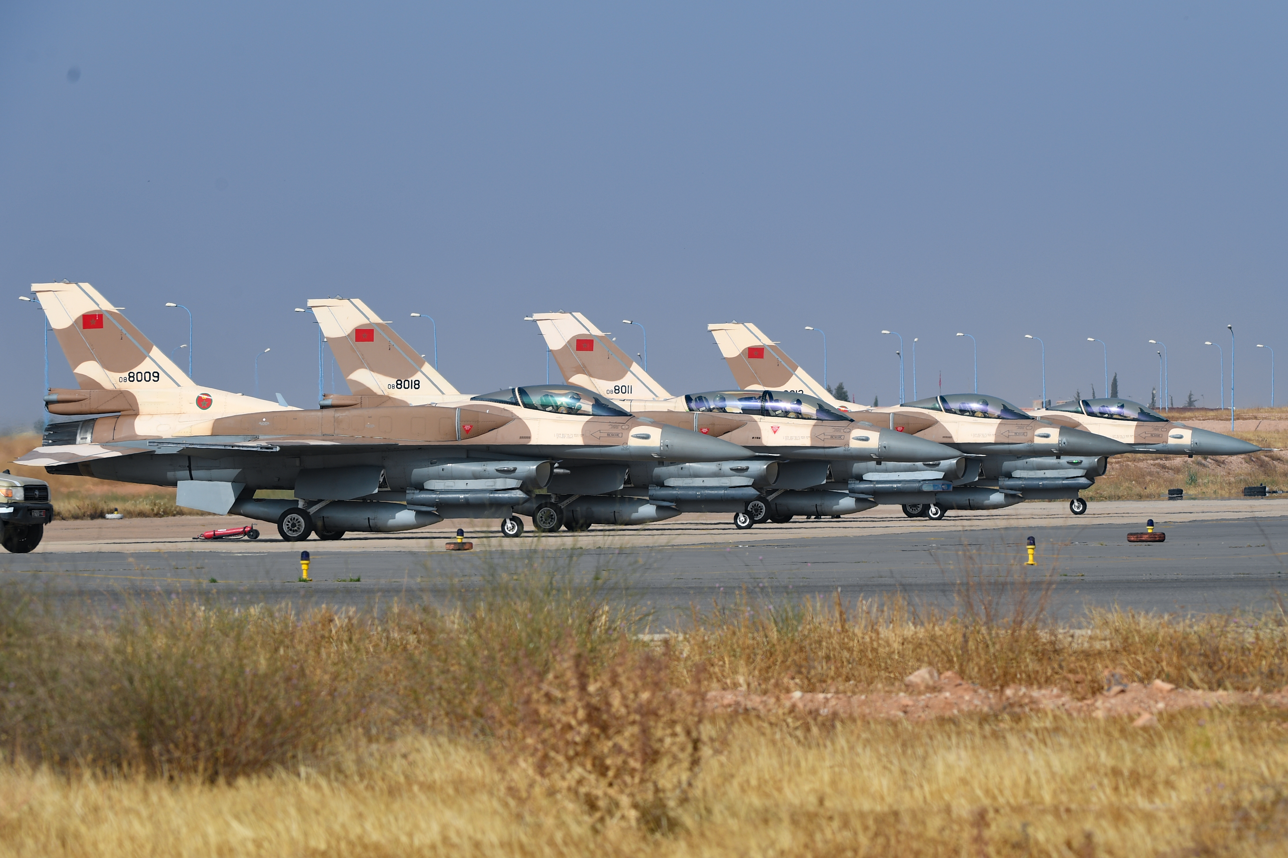 Four Moroccan F-16’s sit on the runway prior to take-off at Ben Guerir Air Base, Morocco, 15 June 2021 during Exercise African Lion 2021. U.S. Air Force and Moroccan F-16’s will fly together over the next week during African Lion. African Lion is AFRICOM’s largest, premier, joint, annual exercise hosted by Morocco, Tunisia and Senegal, 7-18 June. More than 7,000 participants from nine nations and NATO train together with a focus on enhancing readiness for U.S. and partner nation forces. AL21 is a multi-domain, multi-component, and multi-national exercise, which employs a full array of mission capabilities with the goal to strengthen interoperability among participants. (U.S. Air Force photo by Airman 1st Class Thomas S. Keisler IV)
