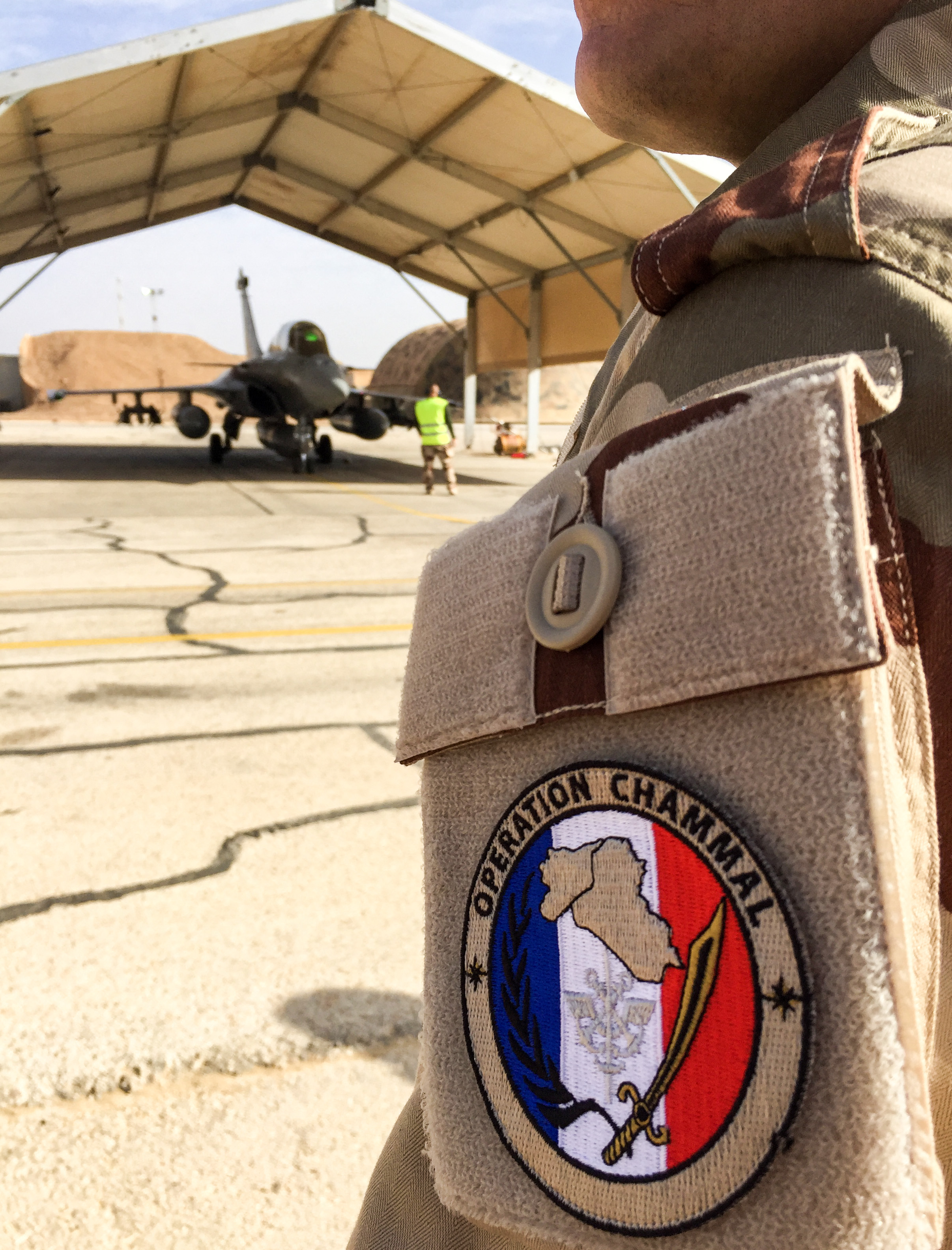 This picture taken on January 1, 2019 shows a French airman displaying the badge signifying "Operation Chammal", the French military operation within "Operation Inherent Resolve", the international coalition against the Islamic State (IS) group, as he stands in front of a Dassault Rafale fighter-bomber aircraft at the Royal Jordanian Air Force's Prince Hassan Air Base (H5), northeast of the capital Amman, from which French fighter jets take-off for sorties against IS. France's defence minister arrived in Jordan on December 31, 2018 to visit troops battling the Islamic State group, showing Paris's determination to continue the fight after a shock US decision to withdraw from Syria. (Photo by Daphné BENOIT / AFP) (Photo by DAPHNE BENOIT/AFP via Getty Images)