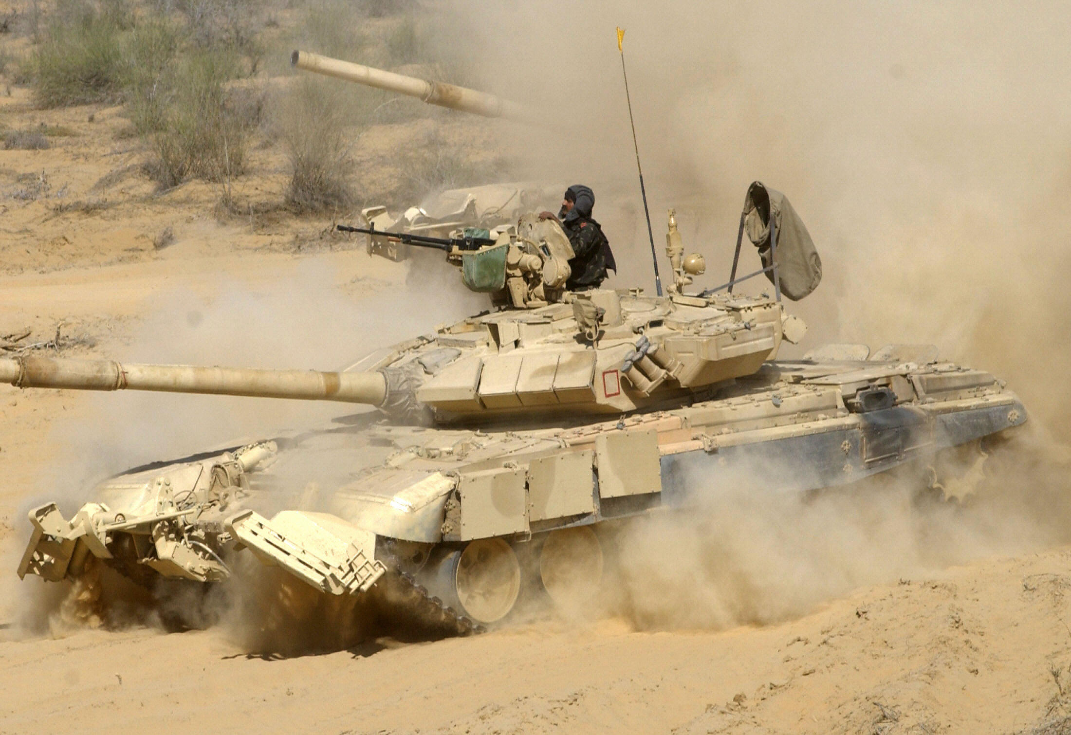 MAHAJAN FIRING RANGE, INDIA: A member of an Indian army tank crew sits in the turret of a T90 tank as it takes part at an Indian Army and Air Force fire power demonstration at Mahajan Firing Range, Rajasthan,some 530 kms west of New Delhi,01 March 2004. Indian Defence Forces displayed their latest infantry weapons and tanks during the demonstration for media representatives. AFP PHOTO/RAVEENDRAN (Photo credit should read RAVEENDRAN/AFP via Getty Images)