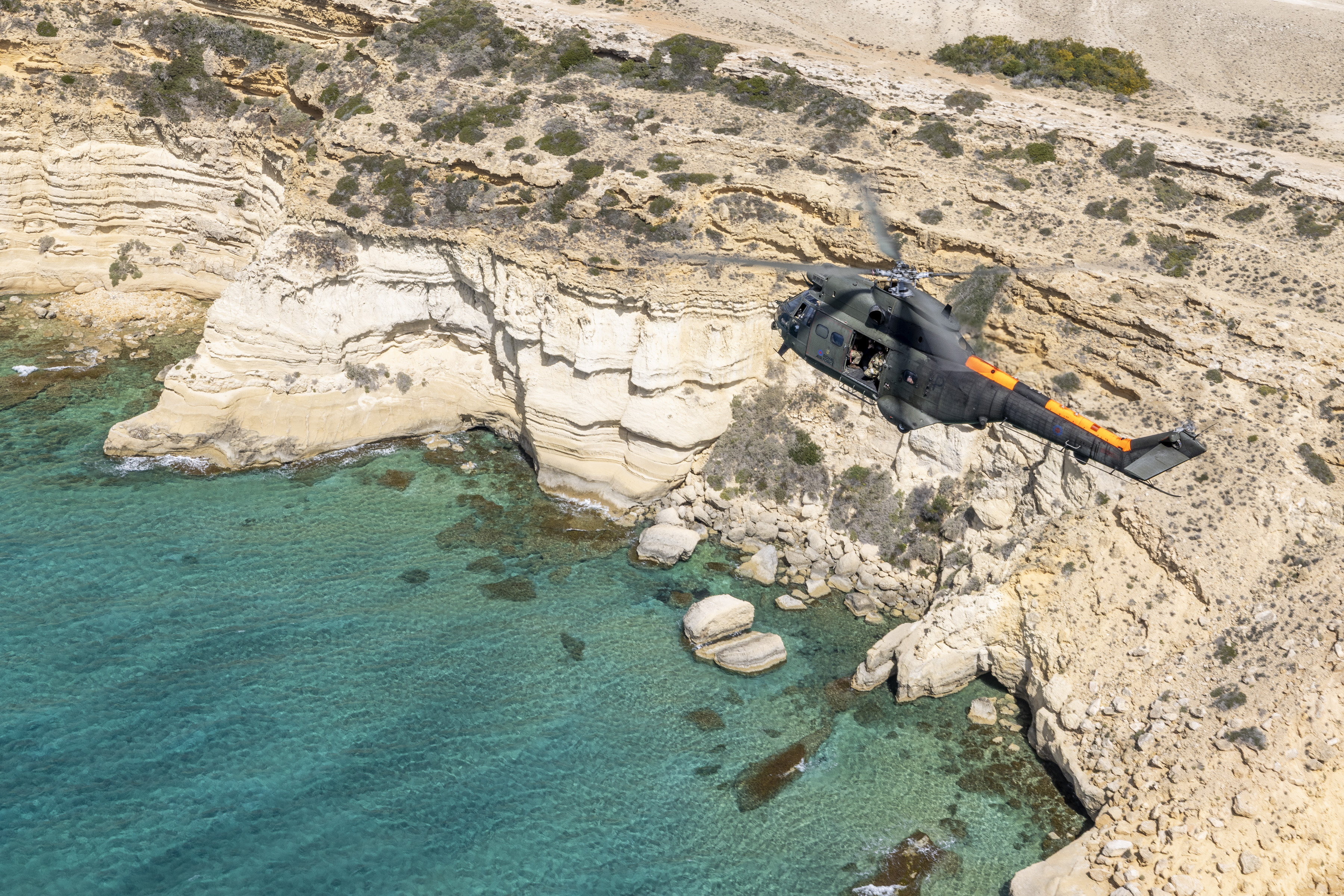 Pictured: 84 Squadron Puma helicopter conducts a farewell flight over Cyprus. On Thursday 27 March 2025, two Puma helicopters from 84 Squadron departed RAF Akrotiri to conduct a farewell flight of Cyprus. The aircraft flew over both the ESBA and WSBA including flypasts over Larnaca International Airport, Dhekelia Station, Ay Nik Station, Nicosia, Episkopi Station, Paphos International Airport, Troodos Mountains, and a final flight over RAF Akrotiri. The RAF Puma Force have supported critical operations on the frontlines, performed life-saving rescues, provided essential firefighting capabilities and delivered humanitarian aid all over the globe for the last 54 years. Introduced into service in 1971, the Puma quickly became a key asset, known for its agility, speed, and versatility. Over the years, it has been deployed in various Operations and humanitarian missions. In recent history it has seen service in Kenya 2009 to 2011 where they supported UK exercises and in Afghanistan 2015 to 2021. It has also provided support in the Caribbean as a part of Operation RUMAN after Hurricane Irma in September 2017. During COVID it took part in Operation RESCRIPT in 2020, providing vital aid to those in need. Up until March 2025, it has been involved in enduring operations in Cyprus and Brunei. RAF Akrotiri is home of the Cyprus Operations Support Unit which provides joint support to British Forces Cyprus and operations in the region to protect the UK's strategic interests.