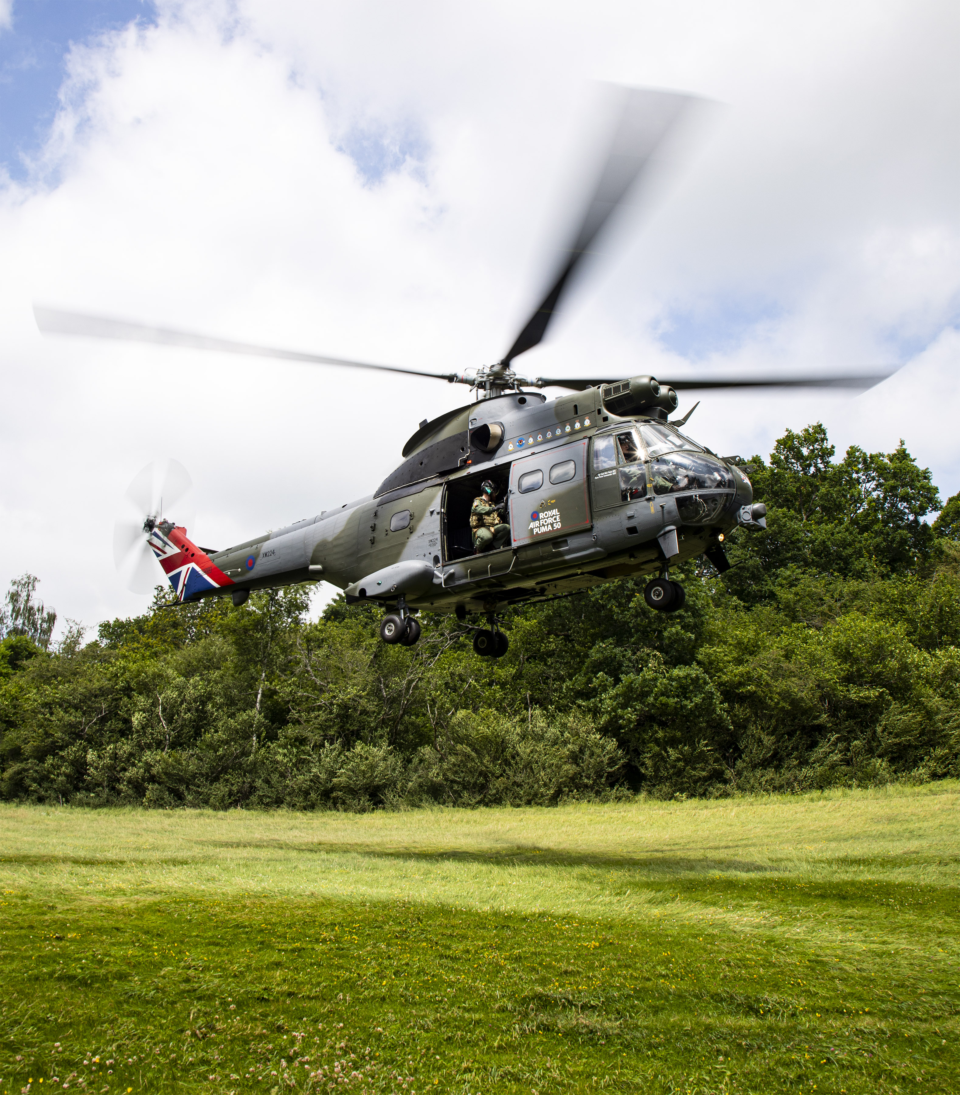 “Agile Landings” A 50th Anniversary Puma helicopter flies over the Oxofordshire countryside on 2nd July 2021, Flight Sergeant Richard Barker is seen in the door of the Puma as it lands at salisbury Plains. As part of the Puma 50th anniversary celebrations and commemorations, Puma HC Mk 2 XW224 has been re-painted in a unique paint scheme. The aircraft scheme is similar to that which the first aircraft were painted when they were delivered in 1971 but with several notable differences. The engine housing boasts the badges of all squadrons who have flown the Puma, both as a HC Mk 1 and a HC Mk 2. The tail fin is also emblazoned with the union flag. On the cabin door, the standard Royal Air Force logo has been replaced with the bespoke Puma 50 logo and the cockpit door is annotated with the name of the first Squadron Commander who brought the aircraft into operational service. SAC Hannah Smoker is an RAF Photographer who is into her last year of service and currently working in the Photographic Section at RAF Benson. She joined the RAF in 2013 after attending the University of Lincoln, studying Media Production. Since then she has served at RAF Marham, RAF Coningsby and with the Red Arrows at RAF Scampton.