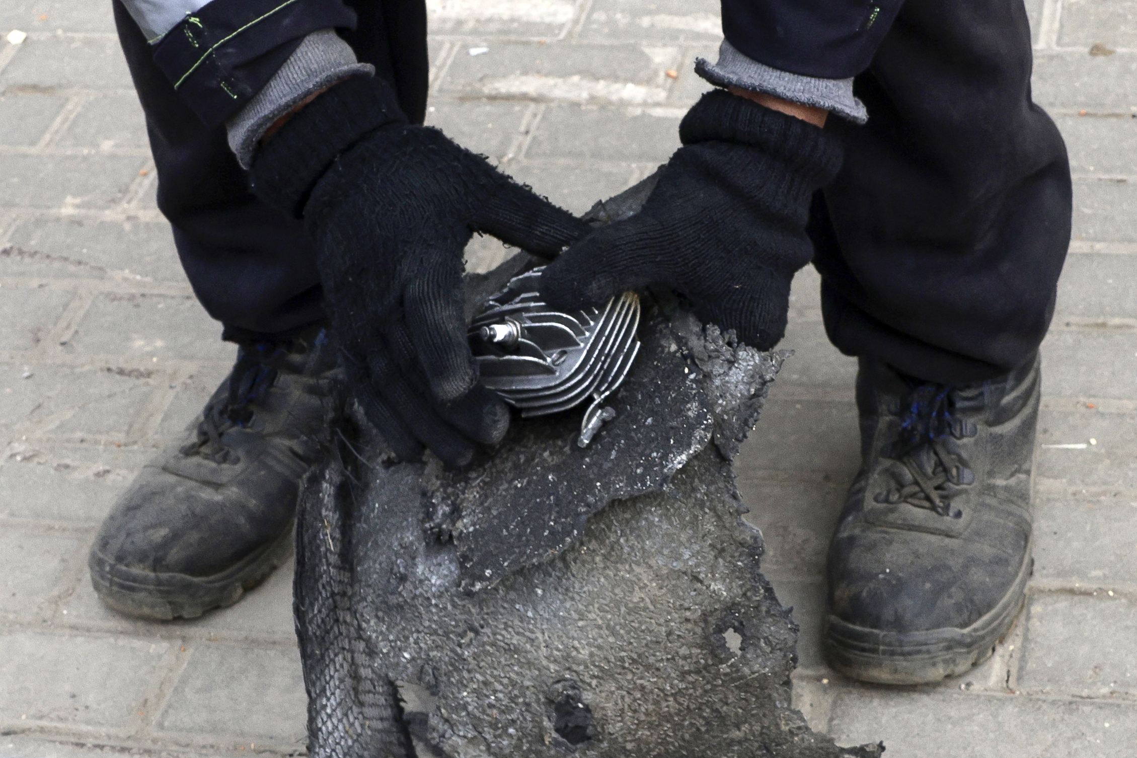 A communal worker clears debris, including what is said a fragment of a downed drone, in the yard of a damaged apartment building following a drone attack in the village of Misaylovo in the Moscow region on March 11, 2025. Ukraine targeted Moscow in a "massive" overnight drone attack, authorities said on March 11, 2025, with Russia's defense ministry claiming it shot down 337 UAVs across the country. (Photo by TATYANA MAKEYEVA / AFP) (Photo by TATYANA MAKEYEVA/AFP via Getty Images)