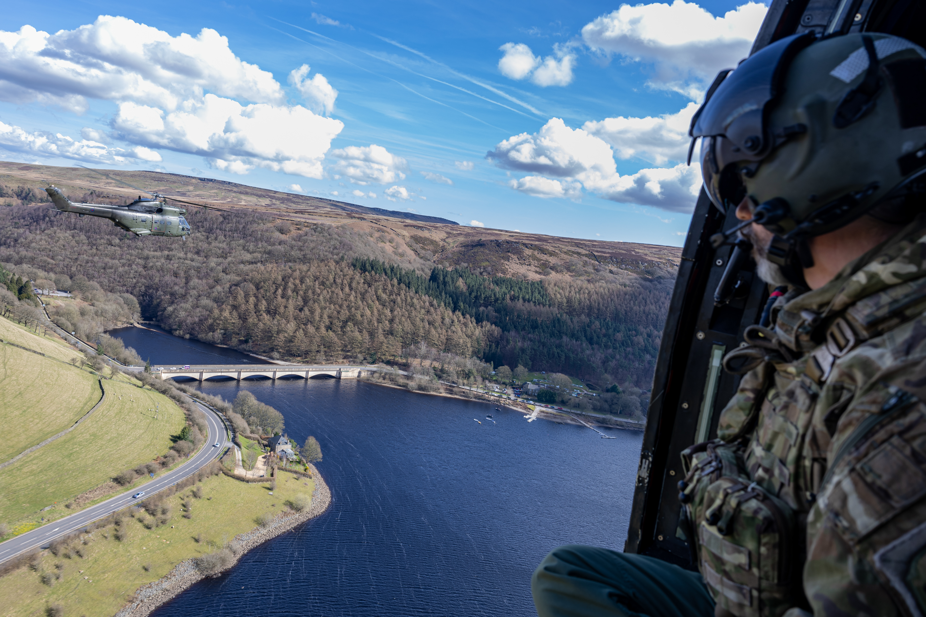 Pictured: 33 Squadron Puma flying over the Derwent reservoir bridge, during their final flight on the 27th. The Puma helicopter departs RAF Benson for the final time as it takes off to fly around the UK as part of its farewell flight. The Puma helicopter has been in Service within the RAF for 54 years and will end its flying days as of 31 March 2025. On 26 March RAF Benson waved off Puma helicopters for the last time as they embarked on their farewell flight around the UK. The Puma helicopter has been the work horse of the Royal Air Force (RAF) for over five decades. Introduced into service in 1971, the Puma quickly became a key asset, known for its agility, speed, and versatility. Over the years, it has been deployed in various Operations and humanitarian missions. In recent history it has seen service in Kenya 2009 to 2011 where they supported UK exercises and in Afghanistan 2015 to 2021. It has also provided support in the Caribbean as a part of Operation RUMAN after Hurricane Irma in September 2017. During COVID it took part in Operation RESCRIPT in 2020, providing vital aid to those in need. Up until March 2025, it has been involved in enduring operations in Cyprus and Brunei.