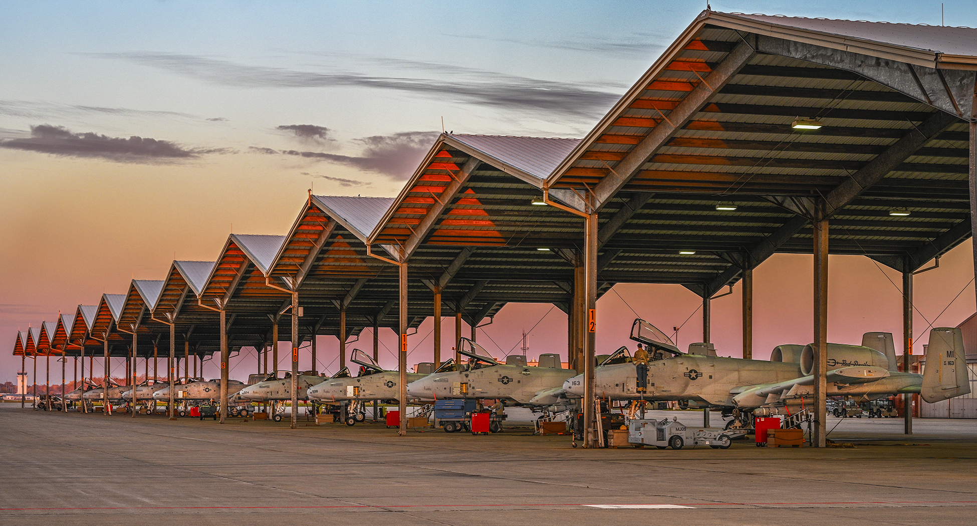 A row of A-10 Thunderbolt II aircraft, also known as the "Warthog", assigned to the 127th Wing, flown by the 107th Fighter Squadron sit ready for operation in the wake of morning day break at Selfridge Air National Guard Base, Michigan on Nov. 2, 2022. With a total of 578,000 square feet of ramp space and an Air Force operated air traffic control tower, Selfridge is home to a ready, reliable and relevant airfield. (Air National Guard photo by Terry L. Atwell)