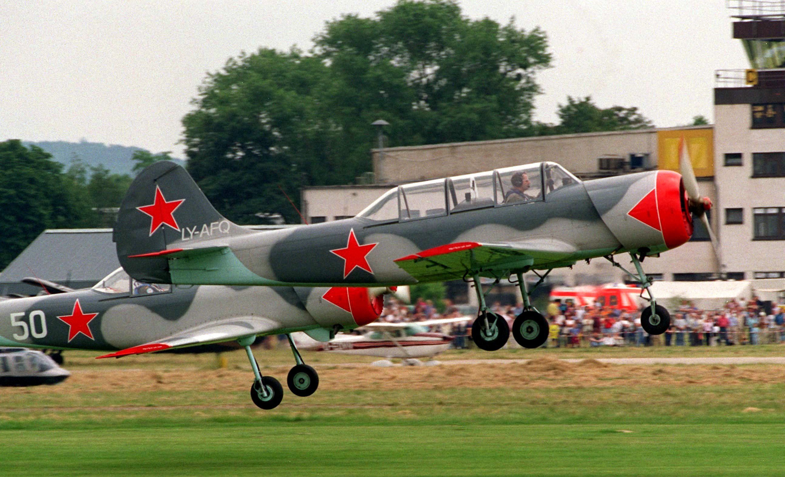 Die Kunstflüge der YAK-52 und YAK-50 gelten am 12. Juni 1999 als Höhepunkt des 3. Flugplatzfestes in Hildesheim. Geflogen wurden die vom russischen Konstrukteur Alexander Jakowlew entwickelten Flugzeuge von den beiden ehemaligen Phantom-Piloten Günther "MDB" Meidenbauer und Rainer Luff vom YAK-Team aus Wittmund. Die Piloten kommentierten für die Besucher ihre Kunststücke aus der Kanzel heraus über eine Lautsprecheranlage am Boden. Zum Programm des zweitägigen Flughafenfestes gehörten auch die Darbietungen von Fallschirmspringern, Segelfliegern, Paragleitern sowie die Vorstellung einer russischen Antonow, dem größten Doppeldecker der Welt. (Photo by Holger Hollemann/picture alliance via Getty Images)