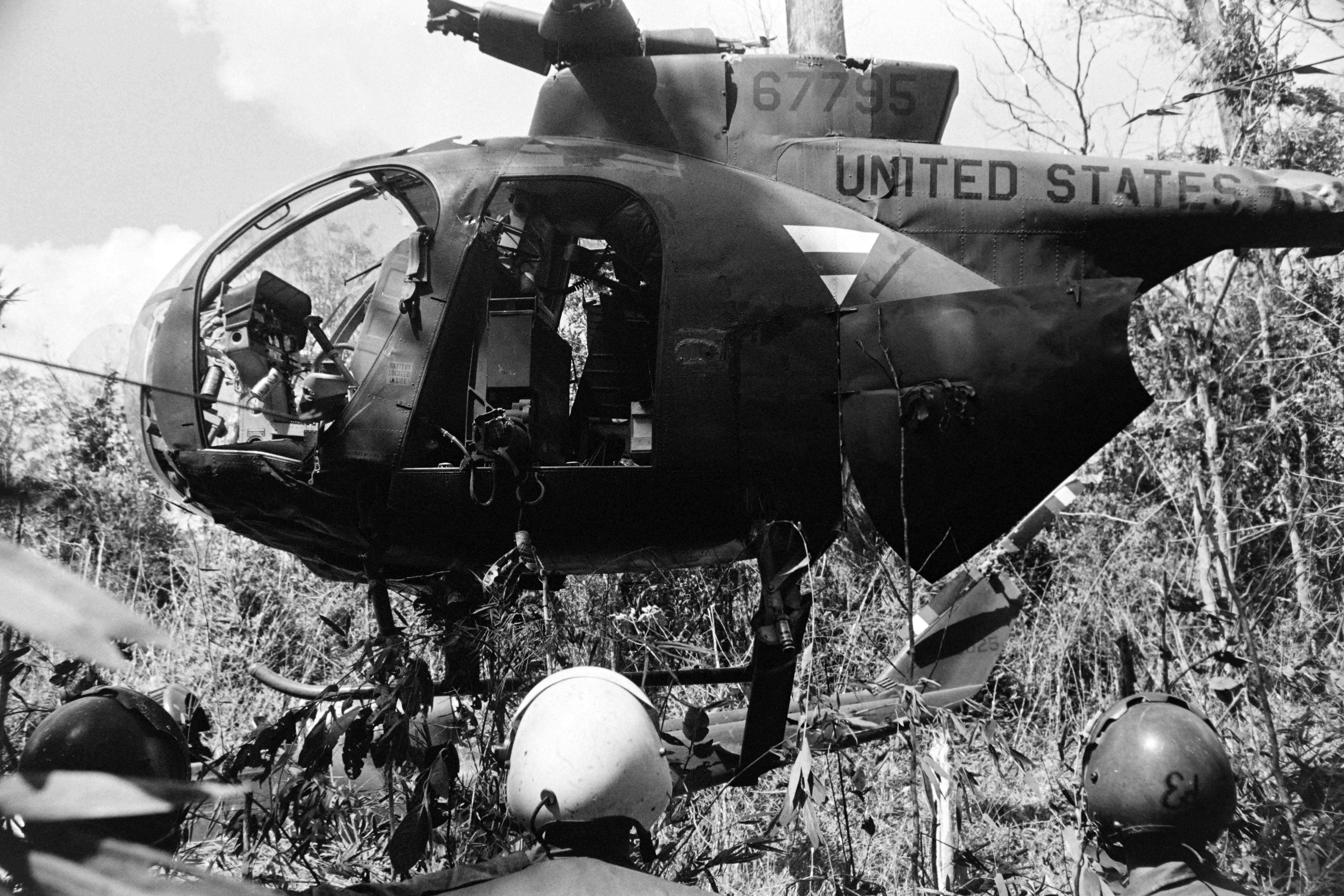 Soldiers of the United States army work on the OH-6 Cayuse US helicopter shot down in Tay Ninh province, on December 1967, during the Vietnam War. (Photo by Bob WILDAU / AFP) (Photo by BOB WILDAU/AFP via Getty Images)