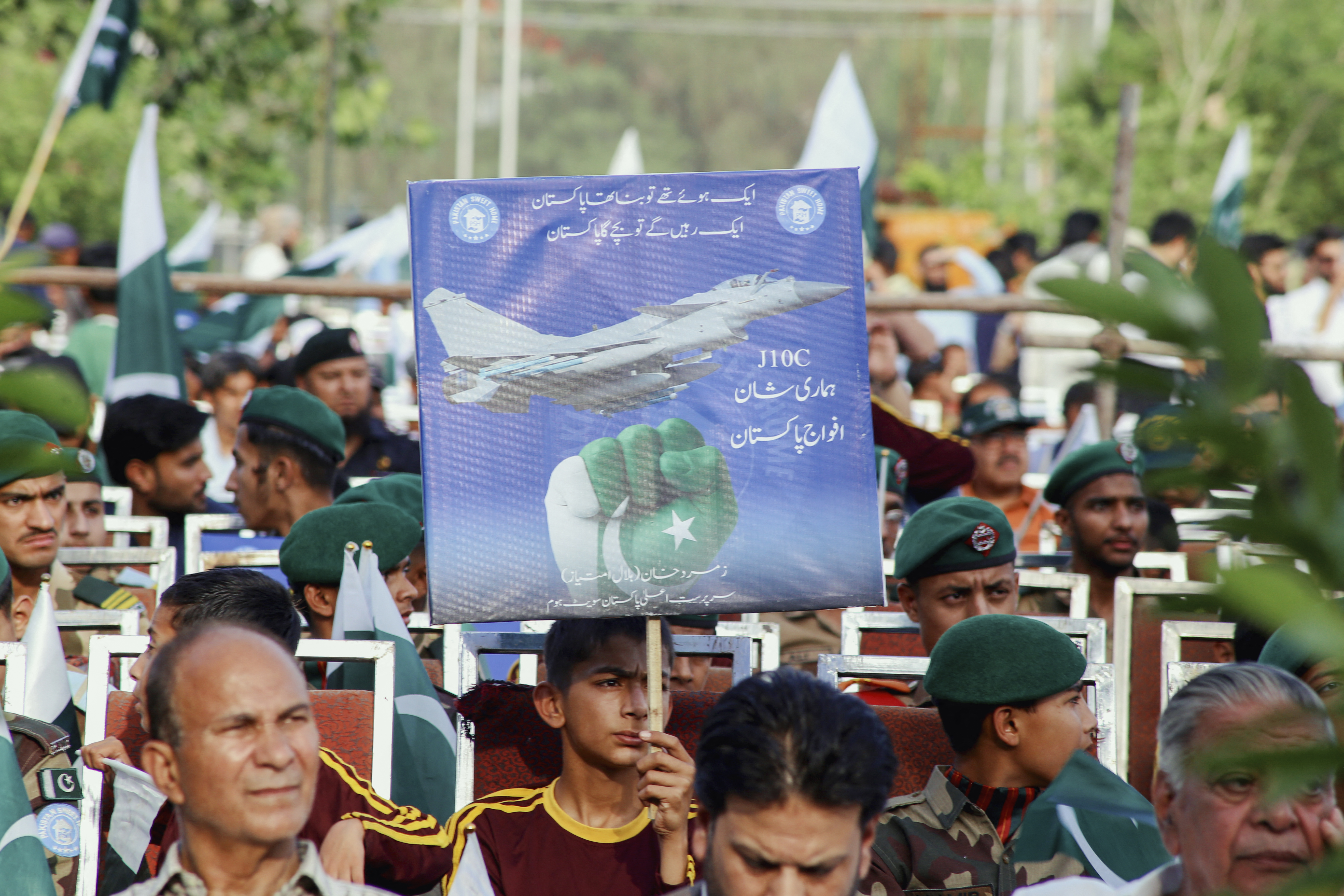 A young boy holds a placard of Chinese fighter jet J10-C as Pakistani people particiapate in a public gathering of gratitude organized by Parks and Horticulture Authorities (PHA) held at Liaquat Bagh in Rawalpindi, Pakistan on Monday, May 12, 2025. (Photo by Zubair Abbasi / Middle East Images / Middle East Images via AFP) (Photo by ZUBAIR ABBASI/Middle East Images/AFP via Getty Images)