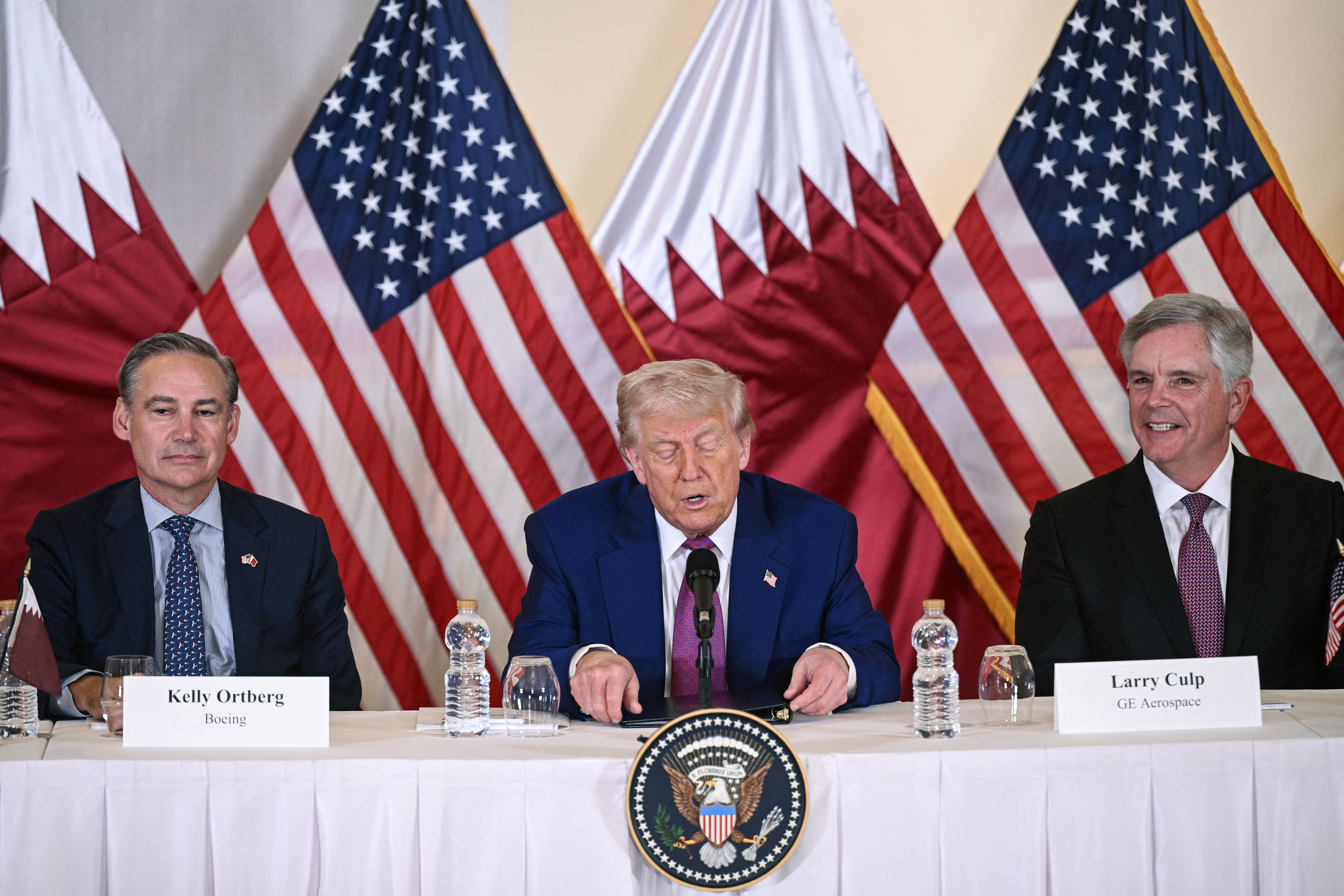 US President Donald Trump (C) is flanked with Boeing CEO Kelly Ortberg (L) and CEO of GE Aerospace Larry Culp during a breakfast with business leaders in Doha on May 15, 2025. (Photo by Brendan SMIALOWSKI / AFP) (Photo by BRENDAN SMIALOWSKI/AFP via Getty Images)