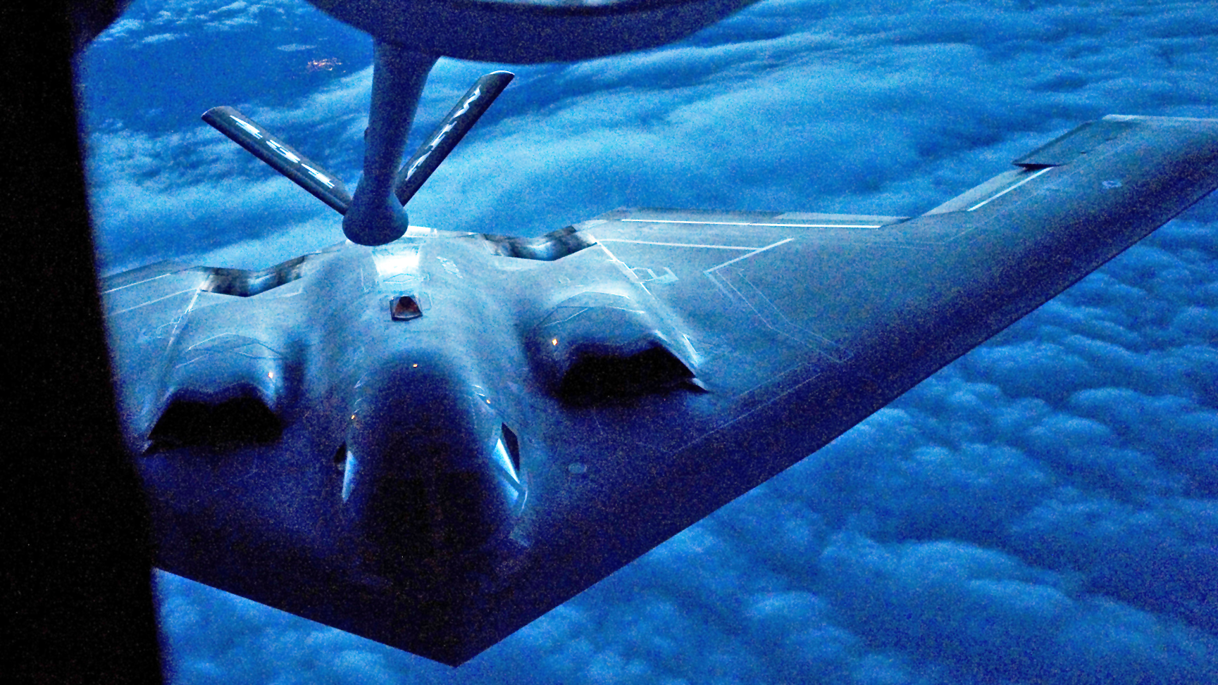 A B-2 Spirit from the 509th Bomb Wing, 13th Bomb Squadron Whiteman Air Force Base, Miss., prepares to be refueled by a KC-135R Stratotanker from the 434th Air Refueling Wing at Grissom Air Reserve Base, Ind. during a nighttime aerial refueling mission over Southern Kansas, Oct. 21, 2015. The KC-135 has a system of exterior lights located on the belly of the aircraft, just behind the nose gear, and flood lights on the boom pod used to pass fuel to the receiver aircraft during low-light conditions. (U.S. Air Force photo/Tech. Sgt. Benjamin Mota)
