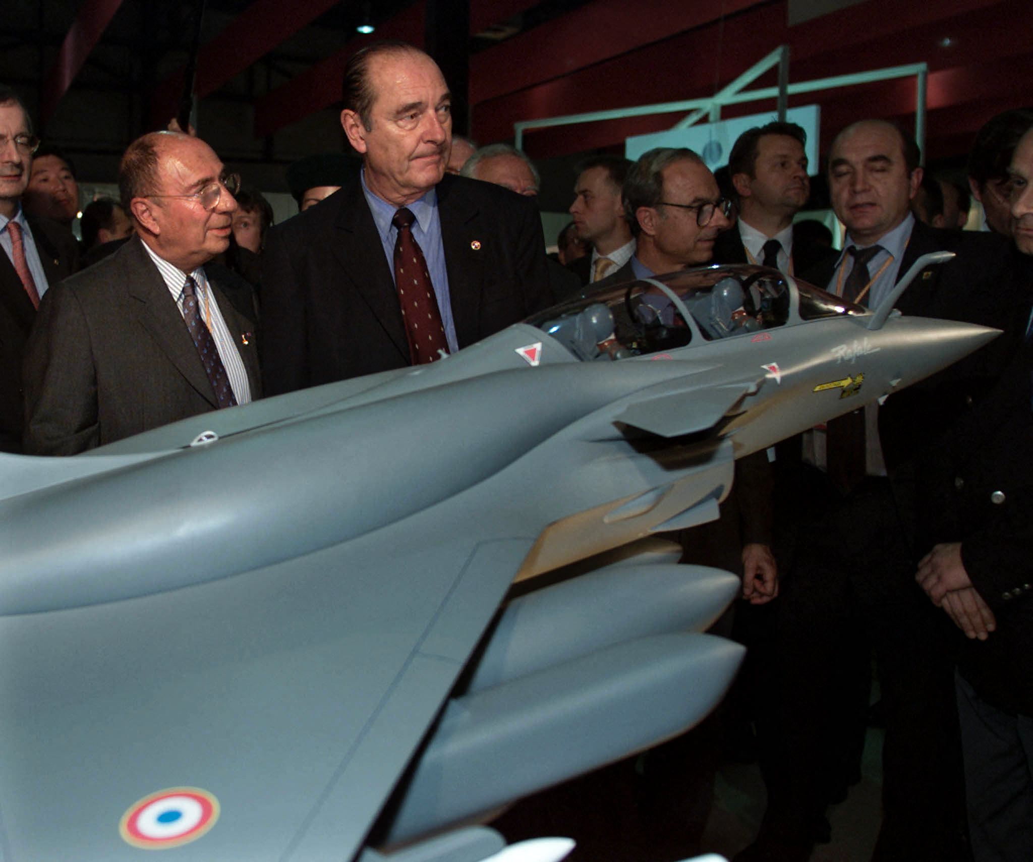 French President Jacques Chirac (C) speaks with French jet-fighters maker Dassault former president Serge Dassault (L) in front of a model of future jet-fighter "Rafale" during a visit to the "France-Korea 2000" fair in Seoul 19 October 2000. Chirac who is in Korea for a three-day official visit, will attend the Asia-Europe Summit Meeting (ASEM). AFP PHOTO/Philippe Wojazer (Photo by PHILIPPE WOJAZER / REUTERS POOL / AFP) (Photo by PHILIPPE WOJAZER/REUTERS POOL/AFP via Getty Images)