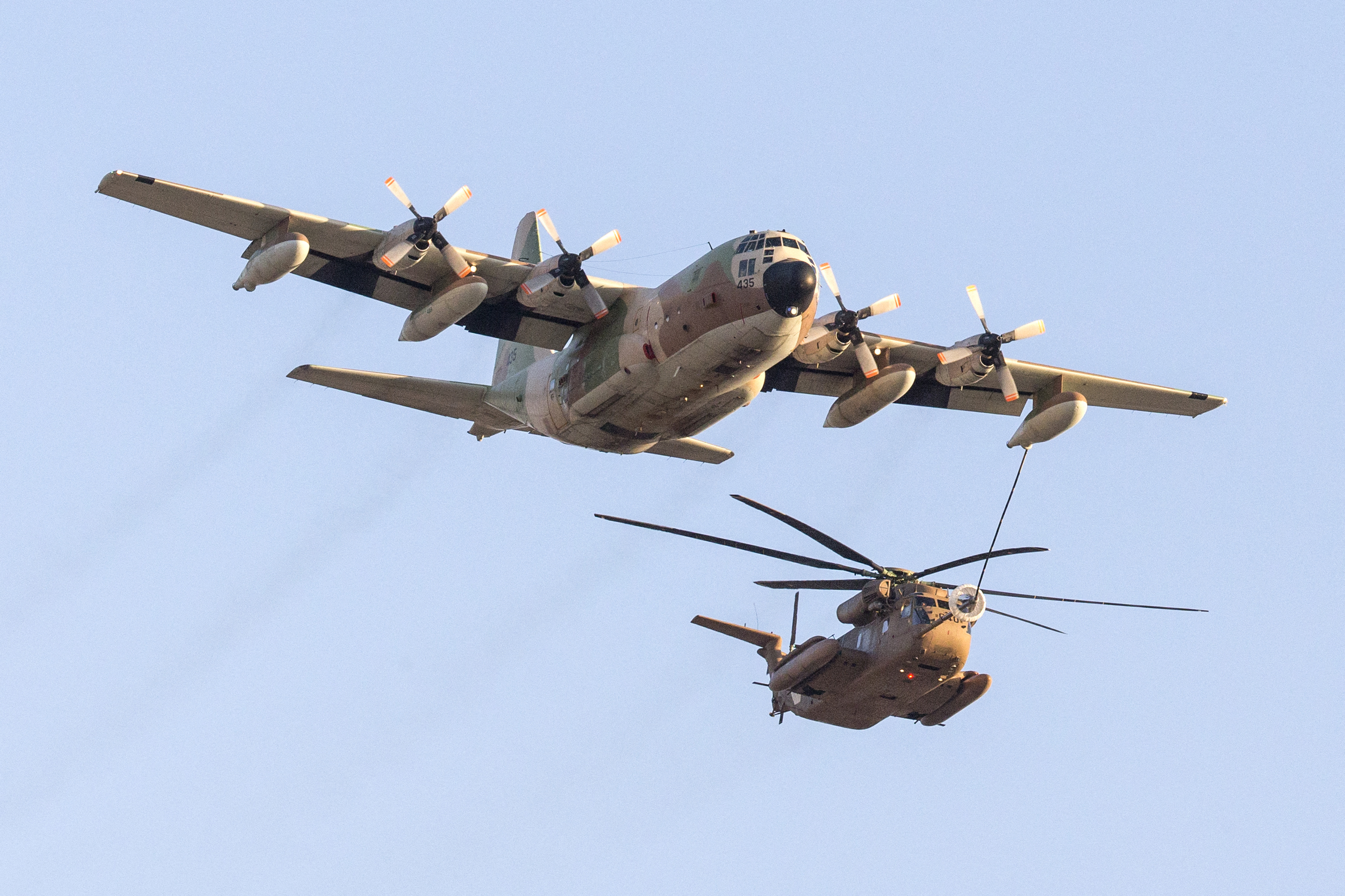 An Israeli C-130 Hercules plane refuels a Sikorsky CH-53K helicopter as they take part in an air show for a graduation ceremony at the Hatzerim base in the Negev desert, near the southern Israeli city of Beersheva, on December 31, 2015. AFP PHOTO / JACK GUEZ (Photo by JACK GUEZ / AFP) (Photo by JACK GUEZ/AFP via Getty Images)