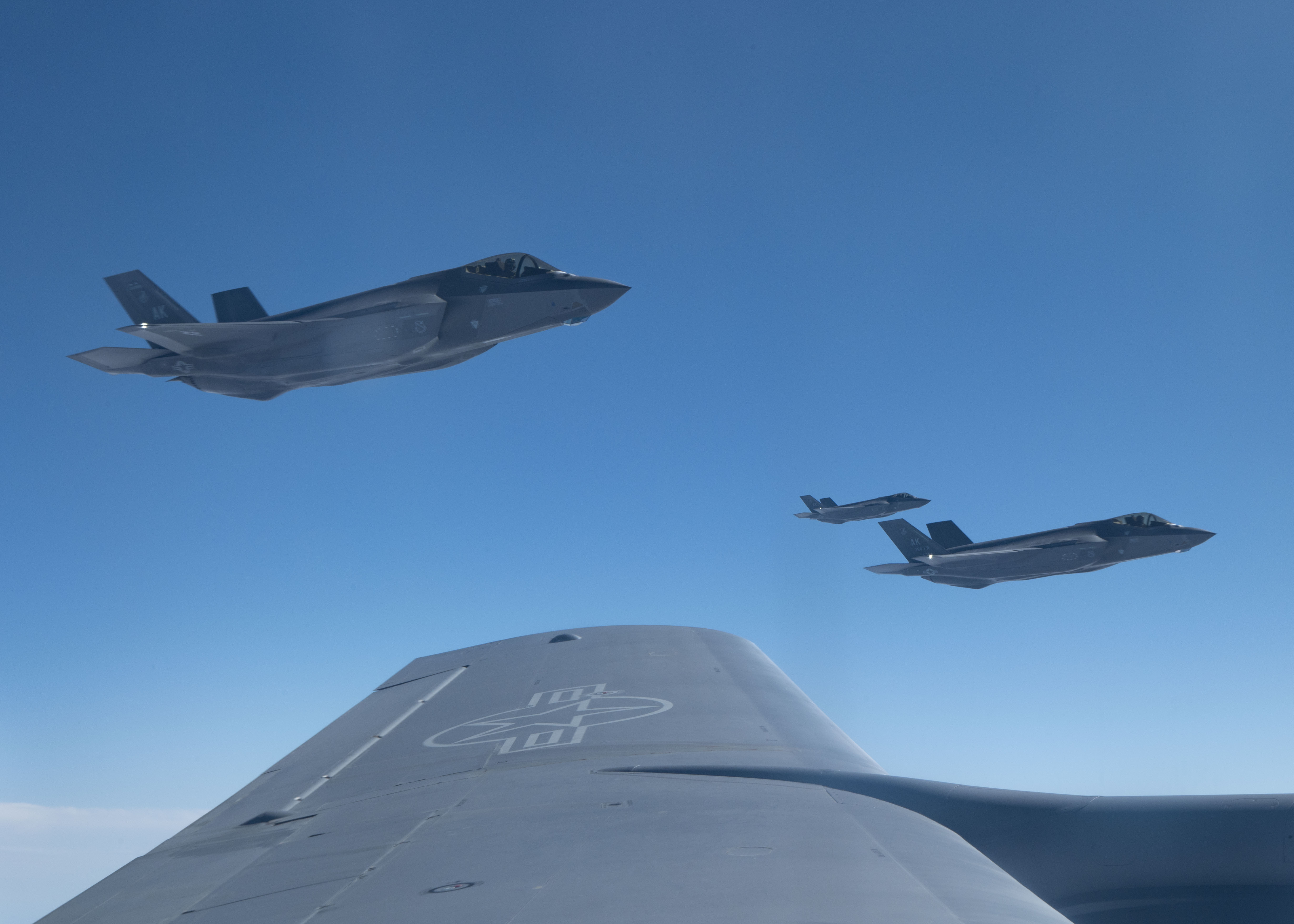 Three F-35 Lightning II fighter aircraft assigned to Eielson Air Force Base, Alaska, fly alongside a KC-135 Stratotanker assigned to the 22nd Air Refueling Wing, McConnell Air Force Base, Kansas, over the Southeast Pacific Ocean during Exercise Bamboo Eagle 25-1, Feb. 10, 2025. Bamboo Eagle allows aircrews to train in combat representative scenarios, enhancing their ability to execute complex refueling operations in contested environments. (U.S. Air Force photo by Airman 1st Class Monique Stober)