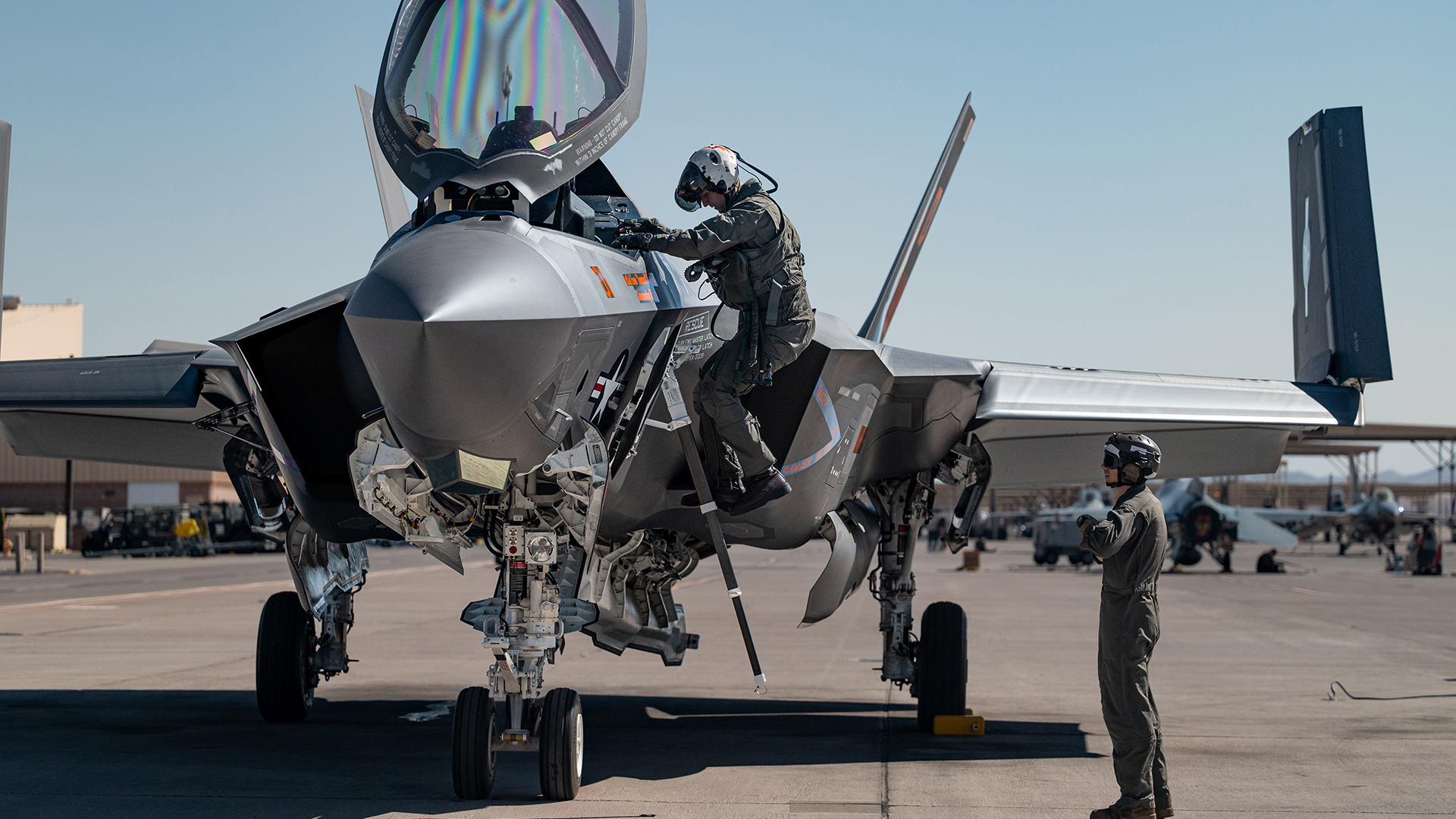 U.S. Marine Corps Capt. Shawn O-Neil, (left) an F-35C Lightning II pilot, and Staff Sgt. Justin Braun, (right) a powerline mechanic, both assigned to Marine Fighter Attack Squadron (VMFA) 251, 2nd Marine Aircraft Wing, Marine Corps Air Station Cherry Point, North Carolina, prepare an F-35C Lightning II before a Red Flag-Nellis 25-3 mission at Nellis Air Force Base, Nevada, July 22, 2025. Red Flag builds joint combat readiness by integrating Marine pilots into realistic, high-threat scenarios, testing their expeditionary reach and rapid deployment capability. (U.S. Air Force photo by Airman 1st Class Jennifer Nesbitt)