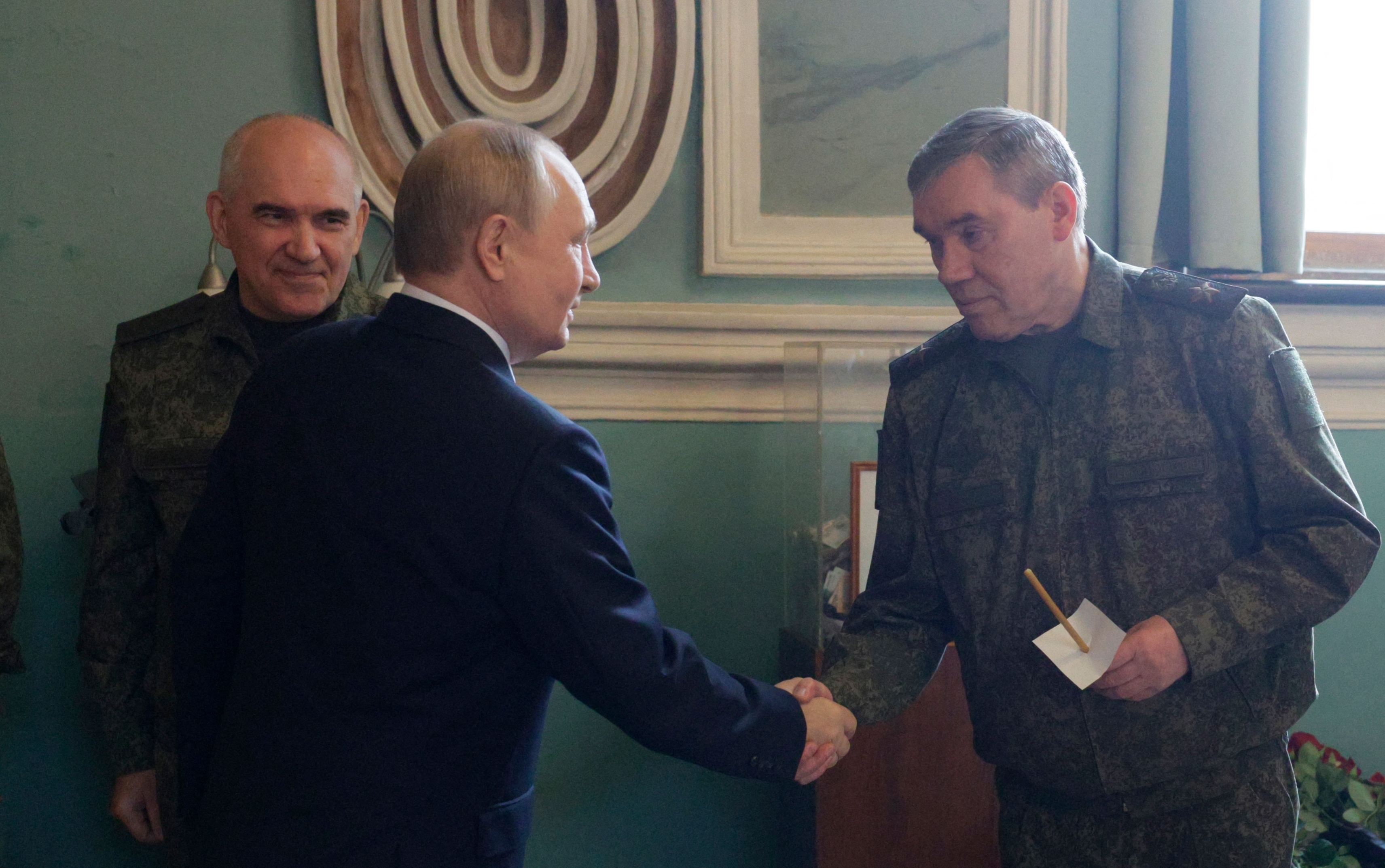 In this pool photograph distributed by the Russian state agency Sputnik, Russia's President Vladimir Putin shakes hands with Chief of Staff Valery Gerasimov while visiting the Peter and Paul Cathedral in Saint Petersburg on October 7, 2025. (Photo by Mikhail METZEL / POOL / AFP) (Photo by MIKHAIL METZEL/POOL/AFP via Getty Images)