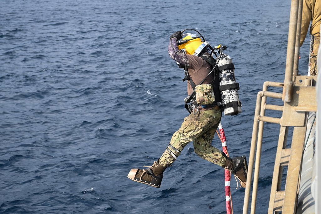 231225-N-GR718-1311 YAKUSHIMA ISLAND, Japan (Dec. 25, 2023) A U.S. Navy Sailor assigned to Commander Task Group 73.6 from Mobile Diving and Salvage Unit ONE jumps into the water from the deck of USNS Salvor (T-ARS 52) during a dive operation amid the ongoing CV-22 Osprey recovery efforts. The U.S. Military, alongside the Japan Coast Guard, Japan Self-Defense Forces, local law enforcement, and Japanese civilian volunteers has been conducting intensive search, rescue and recovery operations for the CV-22 Osprey crew and aircraft debris following the mishap that occurred on Nov. 29 off the shore of Yakushima Island, Japan. Locating and recovering the eighth Airman onboard the CV-22 remains the primary effort. (U.S. Navy Photo by Mass Communication Specialist 1st Class Chelsea D. Meiller)