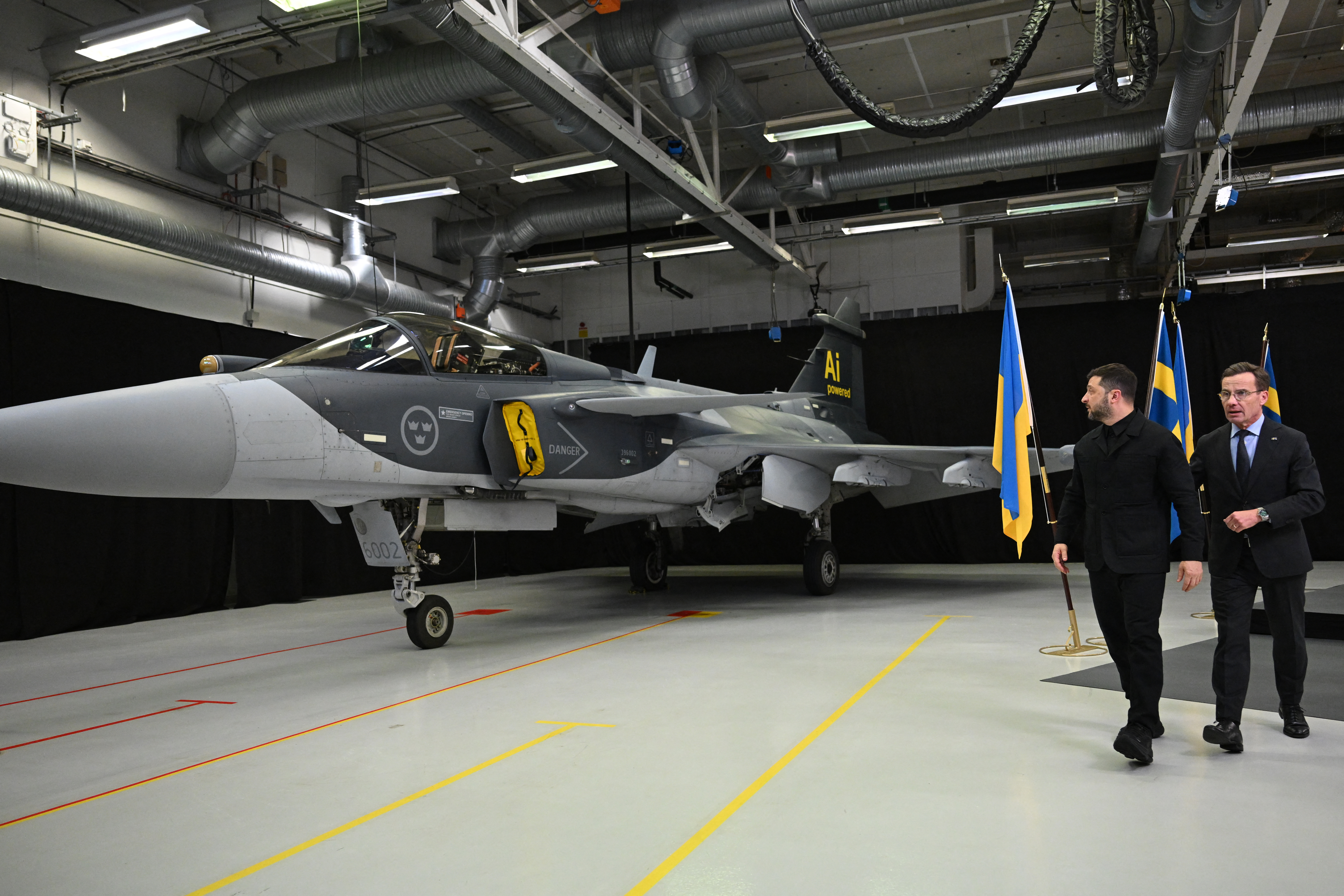 Swedish Prime Minister Ulf Kristersson (R) and Ukrainian President Volodymyr Zelensky walk past a Gripen fighter jet after they delivered a joint press conference in Linkoping, Sweden, on October 22, 2025, after talks on Russia's ongoing of aggression against Ukraine and the countries' deepening defense cooperation. Swedish Prime Minister Ulf Kristersson said on october 22 that Sweden and Ukraine had signed a letter of intent to develop air capabilities, which could see Ukraine buy up to 150 Gripen fighter jets. (Photo by Jonathan Nackstrand / AFP) (Photo by JONATHAN NACKSTRAND/AFP via Getty Images)