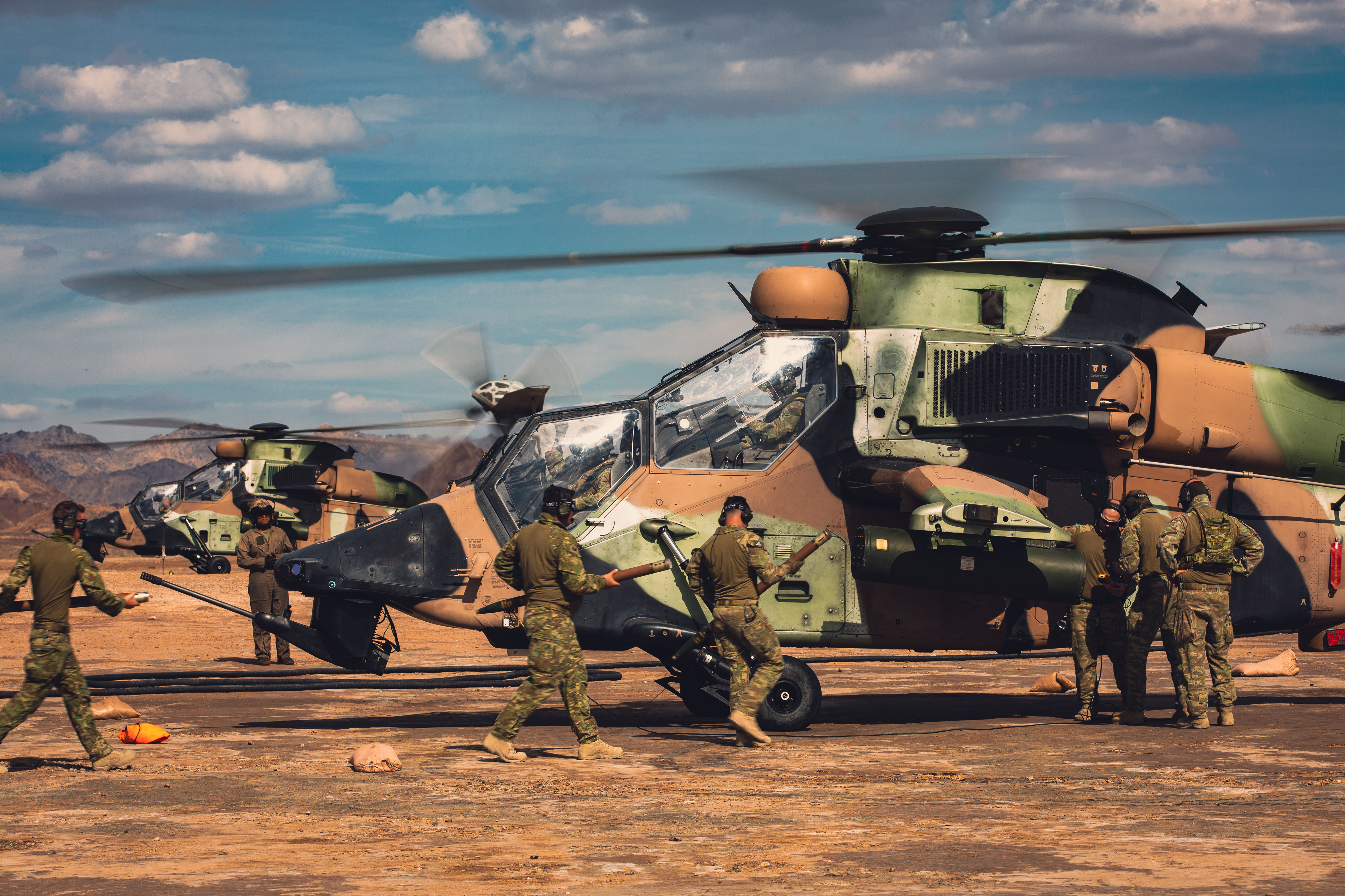 Australian Army Ground Crew Aircraft Support personnel, from the 1st Aviation Regiment, rearm ARH Tigers at a United States Marine Corps CH-53E Super Stallion air deployed ground refuel point, during Exercise Griffin Eagle at Arizona, USA.