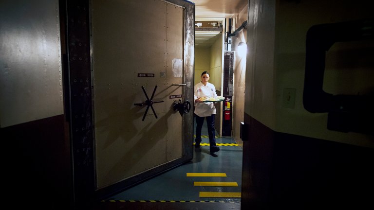 Airman 1st Class Alexandra Ayub walks through a blast door to deliver a meal to the missileers manning the launch control center which is approximately 60 feet beneath the missile alert facility. (U.S. Air Force photo/Staff Sgt. Andrew Lee)