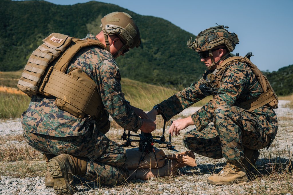 U.S. Marines with III Marine Expeditionary Force load a notional payload on a drone during the Marine Corps Attack Drone Competition on Camp Schwab, Okinawa, Japan, Dec. 9, 2025. During a two-week period, the Marine Corps Attack Drone Team trained and certified 3rd Marine Division Marines as attack drone operators, attack drone instructor, and payload specialist instructors, increasing the Division’s lethality and capacity of trained and certified attack drone operators and instructors. (U.S. Marine Corps photo by Cpl. Joaquin Dela Torre)