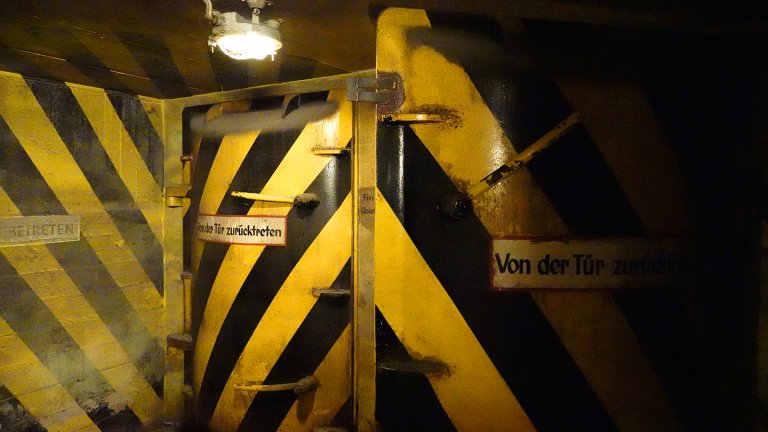 25 July 2022, Hamburg: In front of an entrance to the Steintor underground bunker, yellow and black pressure doors can be seen. The inscription "Stand back from the door" can be read on the doors. The 140-meter-long and 17-meter-wide facility near the main train station had been built from 1941 to 1943. During the Cold War, it had been converted into a nuclear bunker and would have provided shelter for 2700 people in an emergency. Since 2007, the Hamburg Underworlds association has organized guided tours and cultural events in the underground bunker so that the history of this place is not forgotten. Photo: Julian Weber/dpa (Photo by Julian Weber/picture alliance via Getty Images)