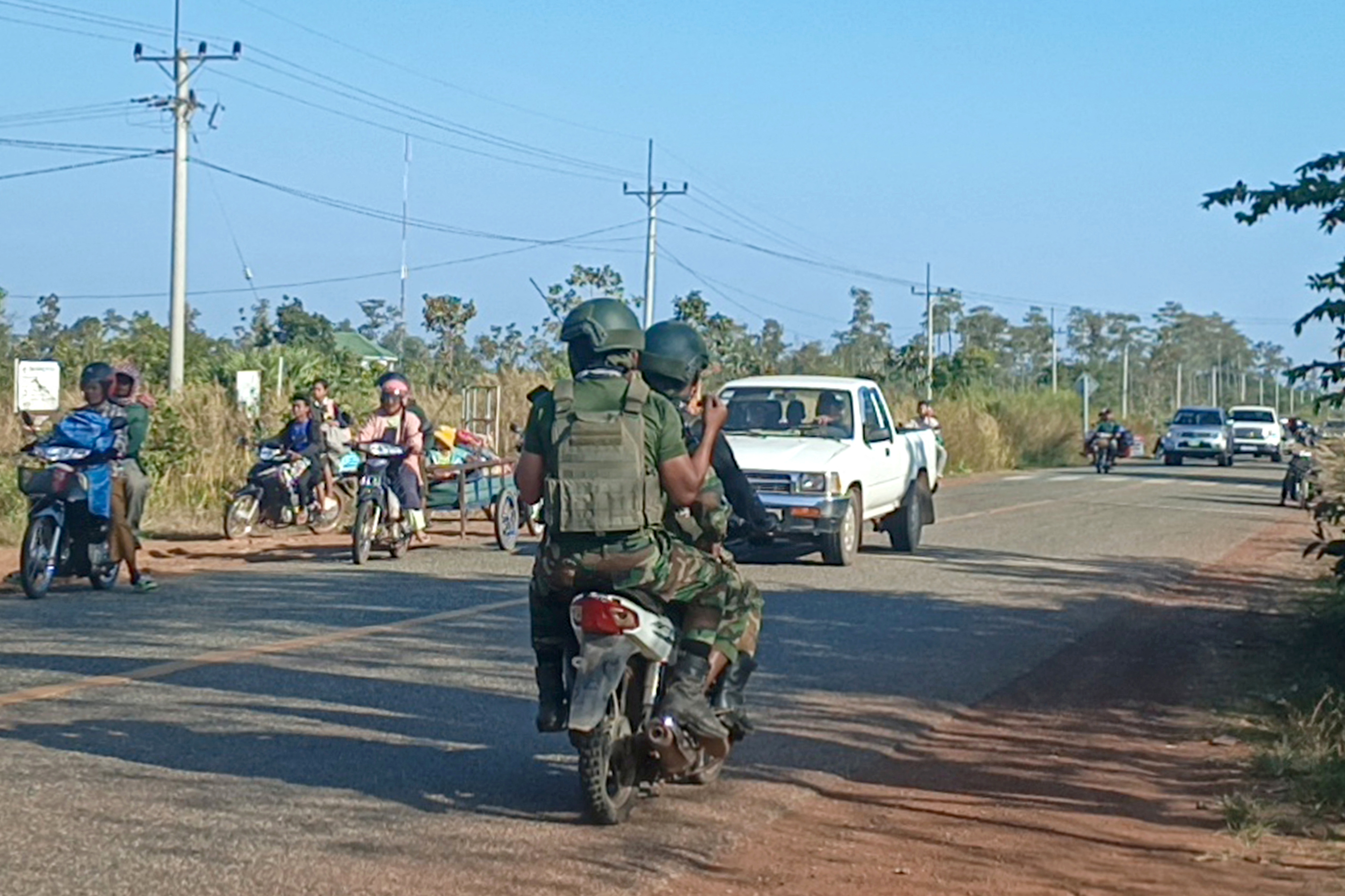 Cambodian soldiers (C) ride their motorbike as local residents evacuate following clashes along the Cambodia-Thailand border in Preah Vihear province on December 8, 2025. A Thai soldier was killed and several others were wounded in fresh border clashes with Cambodia, Thailand's army said on December 8, 2025, with both sides trading blame for the latest eruption in fighting along their frontier. (Photo by AFP via Getty Images)