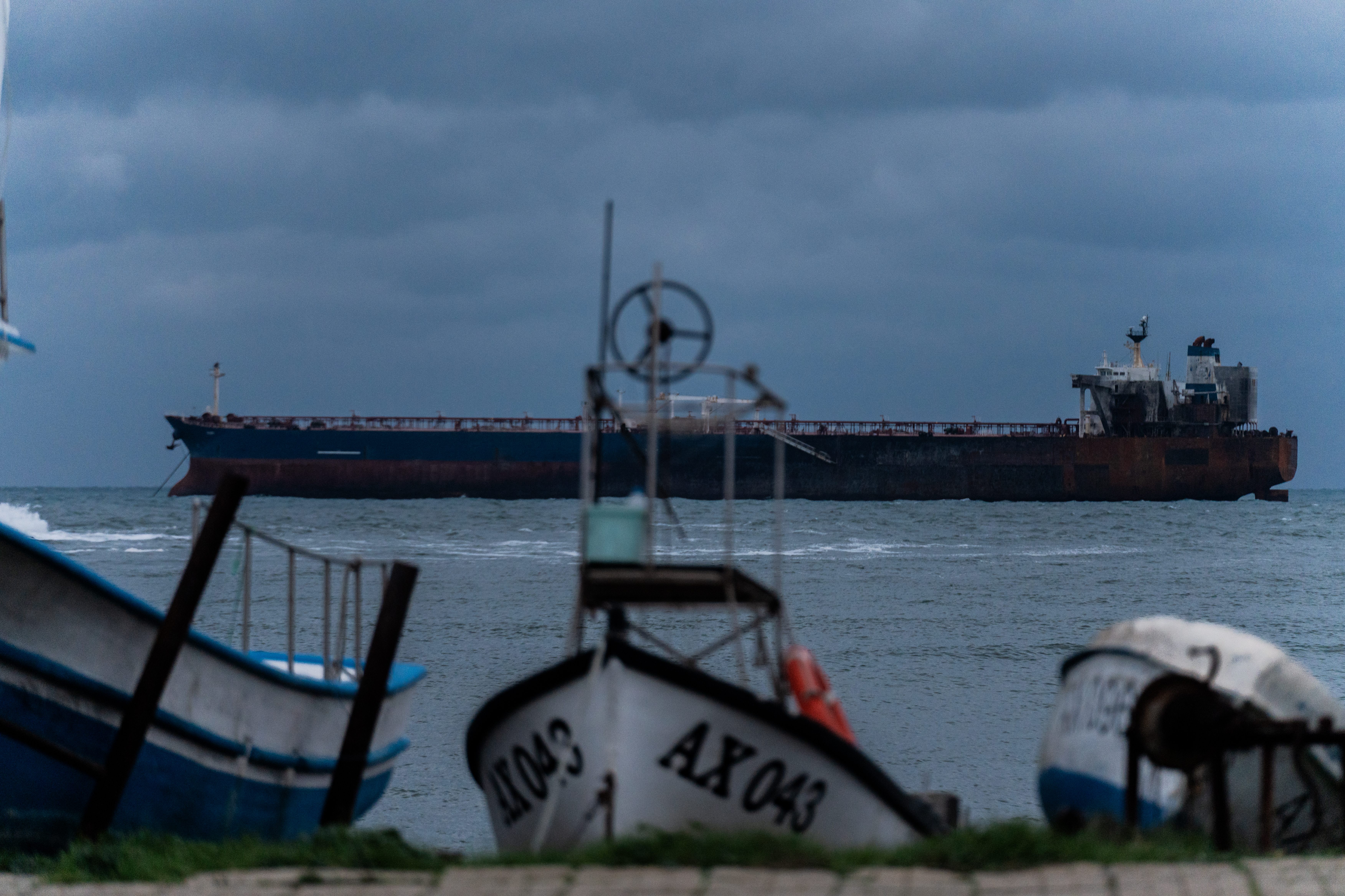 AHTOPOL, BULGARIA - DECEMBER 8: The Kairos oil tanker, a Gambian-flagged vessel believed to be part of Russia's shadow fleet, remains anchored on December 8, 2025 in Ahtopol, Bulgaria. Last week, the ship was sailing from Egypt toward the Russian port of Novorossiysk when it caught fire after an alleged attack by Ukrainian naval drones. Bulgarian maritime authorities are planning the evacuation of the remaining crew. The tanker was sanctioned by the European Union in July for its involvement in Russia's so-called shadow fleet, a clandestine network of vessels that help the country skirt price-capping sanctions on Russian oil sales, penalties that were imposed after the 2022 invasion of Ukraine. (Photo by Hristo Rusev/Getty Images)