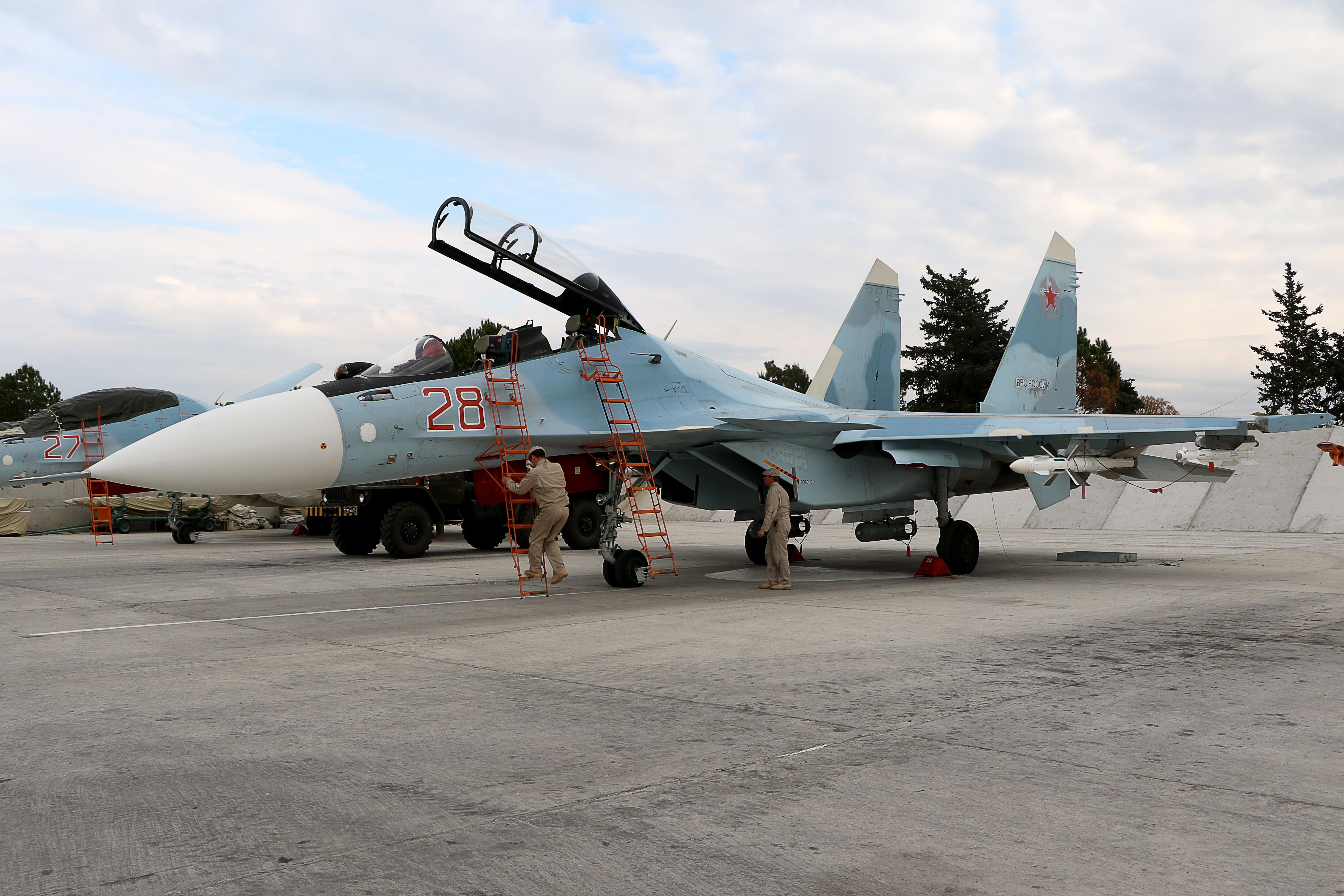 Russian servicemen prepare a Russian air force Sukhoi Su-30SM fighter jet before a departure for a mission at the Russian Hmeimim military base in Latakia province, in the northwest of Syria, on December 16, 2015. - Russia began its air war in Syria on September 30, conducting air strikes against a range of anti-regime armed groups including US-backed rebels and jihadist groups. Moscow has said it is fighting and other "terrorist groups," but its campaign has come under fire by Western officials who accuse the Kremlin of seeking to prop up Syrian President Bashar al-Assad. (Photo by Paul GYPTEAU / AFP) (Photo by PAUL GYPTEAU/AFP via Getty Images)