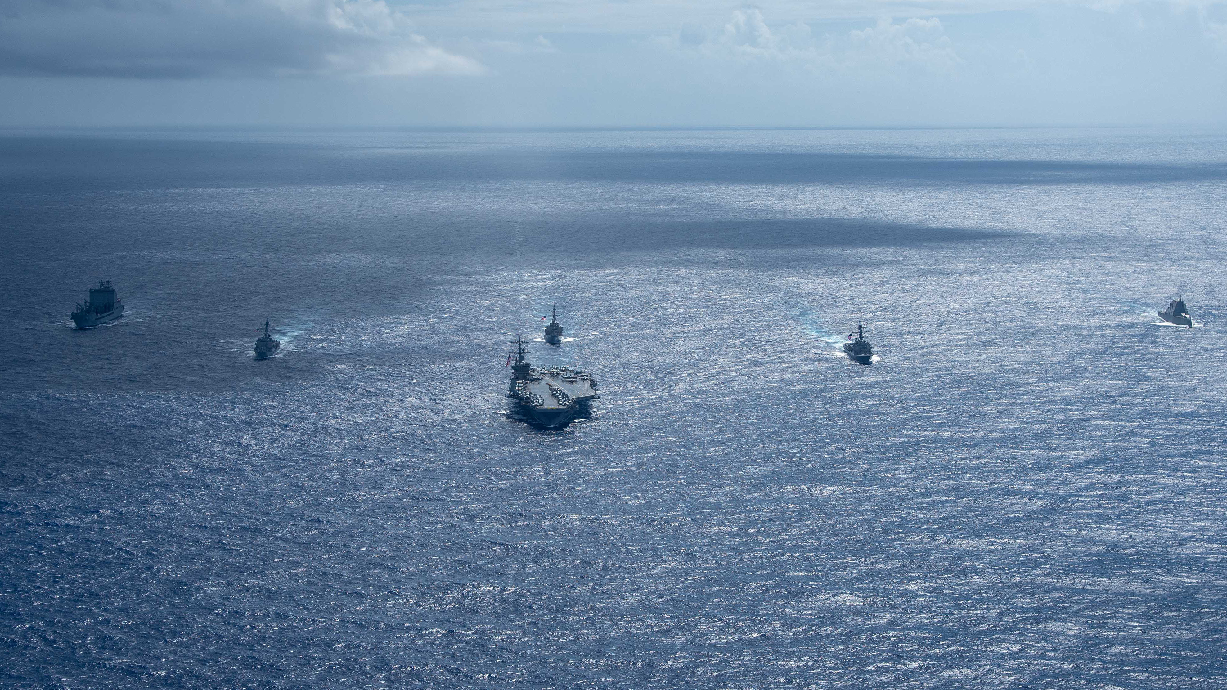 Ships from the Nimitz Carrier Strike Group, Zumwalt-class destroyer USS Michael Monsoor (DDG 1001), far right, and fleet replenishment oiler USNS John Lewis (T-AO 205), far left, steam in formation in the Pacific Ocean, April 10, 2025. The Nimitz CSG is underway in the U.S. 7th Fleet area of operations on a scheduled deployment, demonstrating the U.S. Navy's unwavering commitment to a free and open Indo-Pacific. (U.S. Navy photo by Mass Communication Specialist 2nd Class Carson Croom)