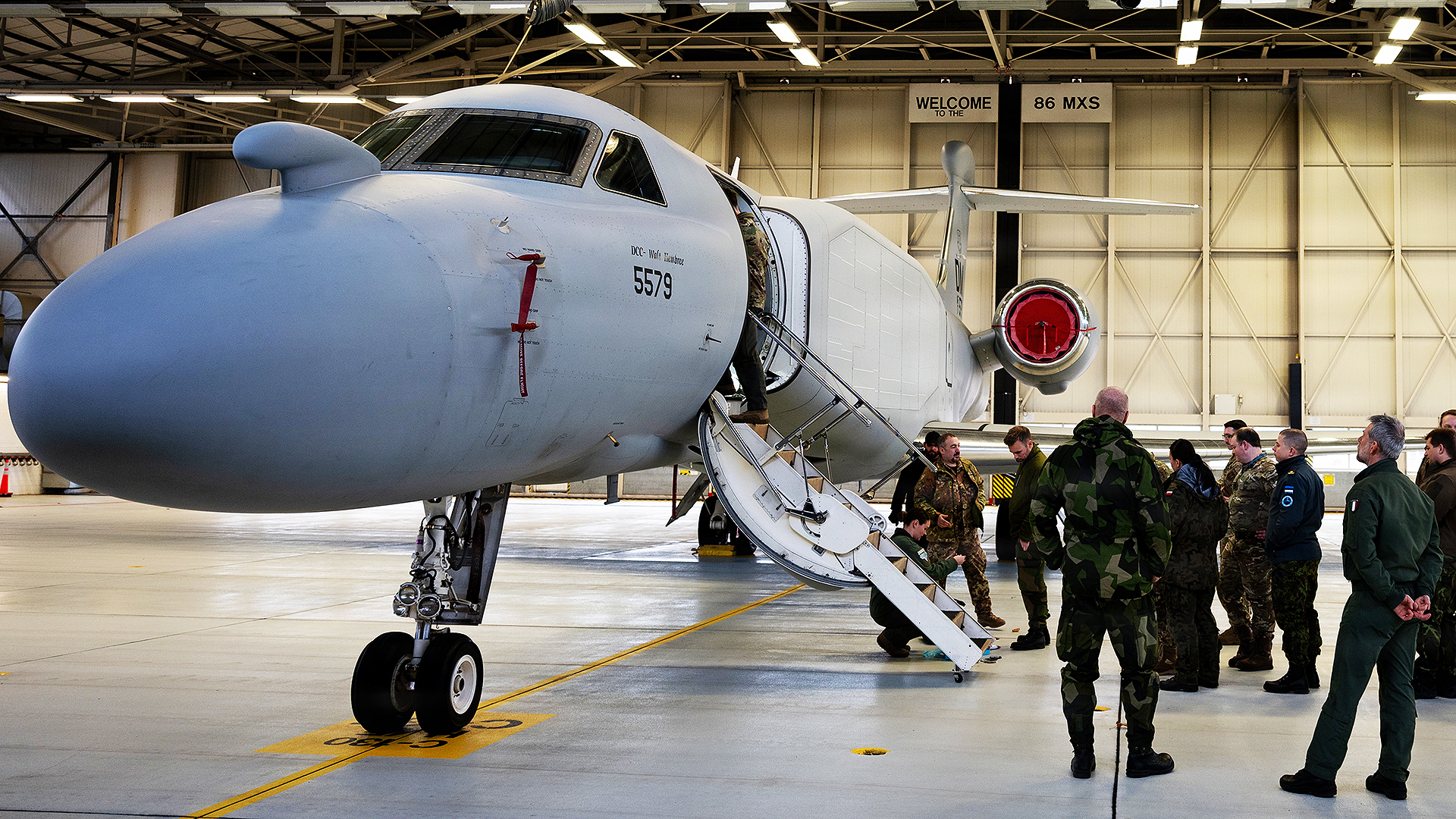 Military personnel assigned to Ramstein Air Base, Germany, receive a tour of an EA-37B Compass Call aircraft assigned to the 55th Electronic Combat Group, Davis-Monthan Air Force Base, Arizona, during its first stop in the European theater for a scheduled road show, Jan. 26, 2026. The roadshow’s inclusion of multiple installations and units highlights the EA-37B’s potential to integrate into various mission sets and teams, serving as a key node for joint and coalition operations. (U.S. Air Force photo by Senior Airman Edgar Grimaldo)