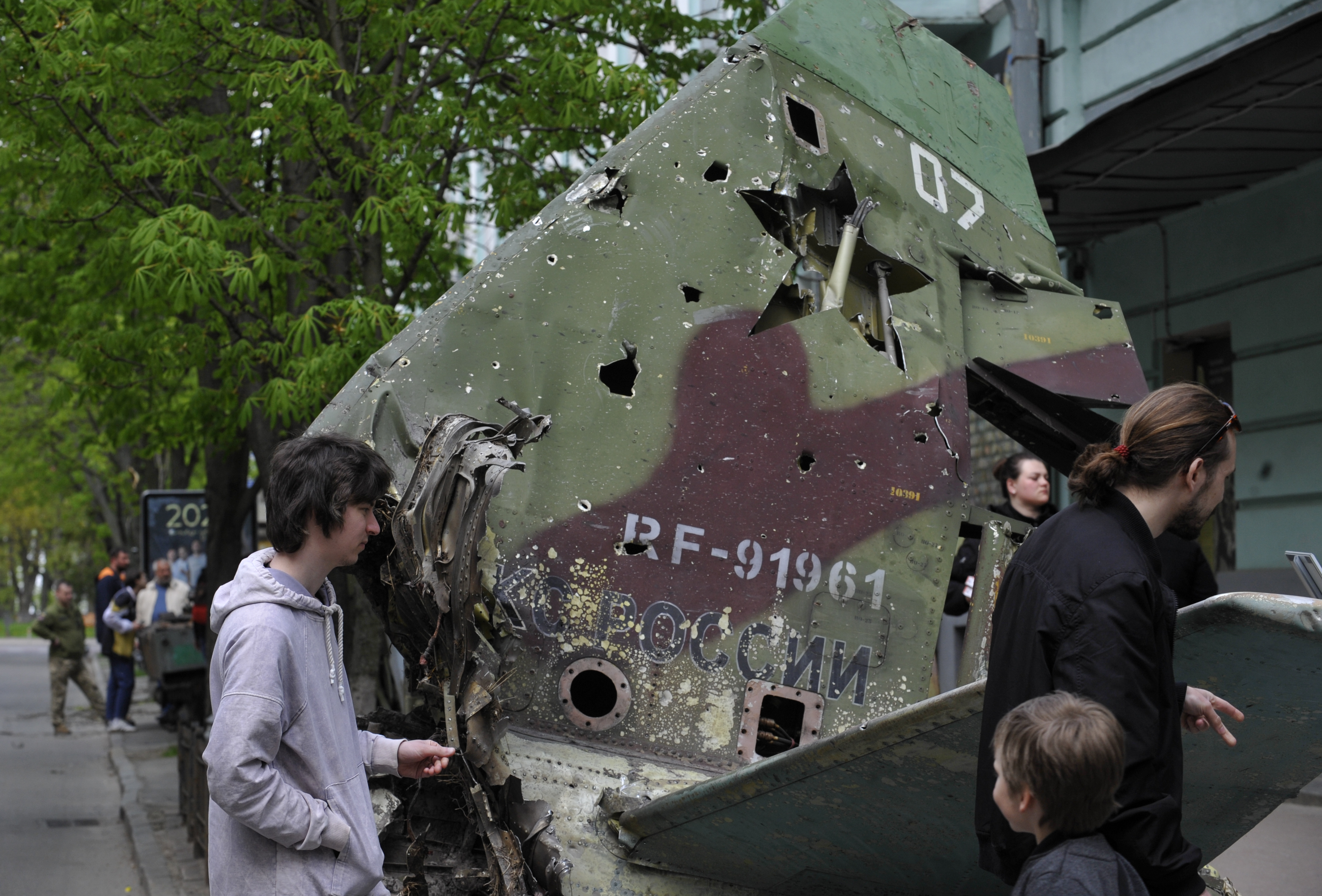 KYIV, UKRAINE - 2022/05/02: People look at the tail section of a Russian Su-25SM aircraft near the military museum in Kyiv to showcase to passersby. The attack aircraft was shot down by the Ukrainian military on March 2 in the Kyiv region. It was destroyed by the Ukrainian military in the Kiyv region then brought into Kyiv for display. Russia invaded Ukraine on 24 February 2022, triggering the largest military attack in Europe since World War II. (Photo by Sergei Chuzavkov/SOPA Images/LightRocket via Getty Images)