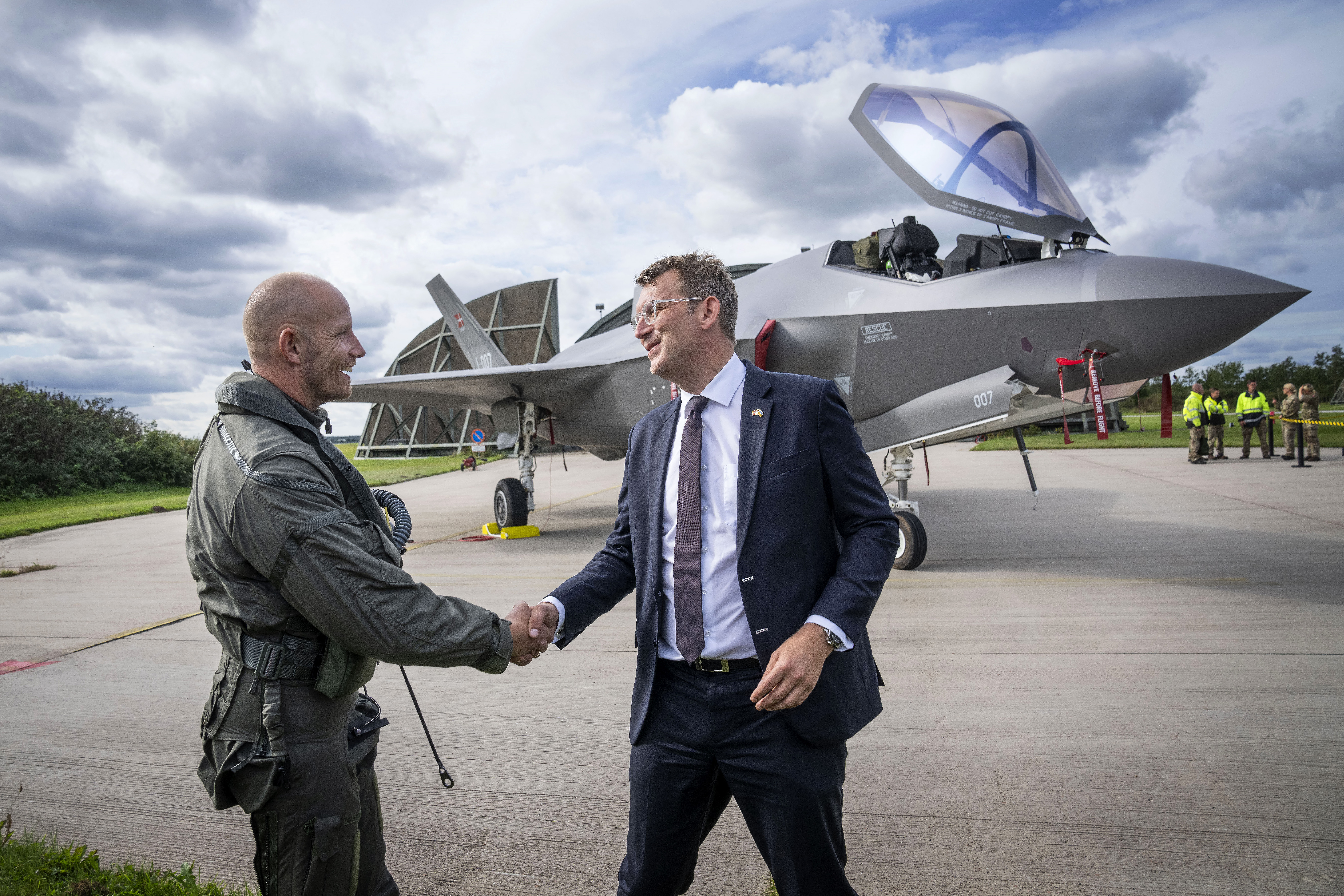 Denmark's Minister of Defense Troels Lund Poulsen (R) greets the F-35 pilot nicknamed PLA, who flew the first F-35 aircraft with serial number L-007 to the Skrydstrup base of the Royal Danish Air Force in Denmark, on September 14, 2023. Denmark receives the first batch of four F-35 fighter jets. (Photo by Bo Amstrup / Ritzau Scanpix / AFP) / Denmark OUT (Photo by BO AMSTRUP/Ritzau Scanpix/AFP via Getty Images)