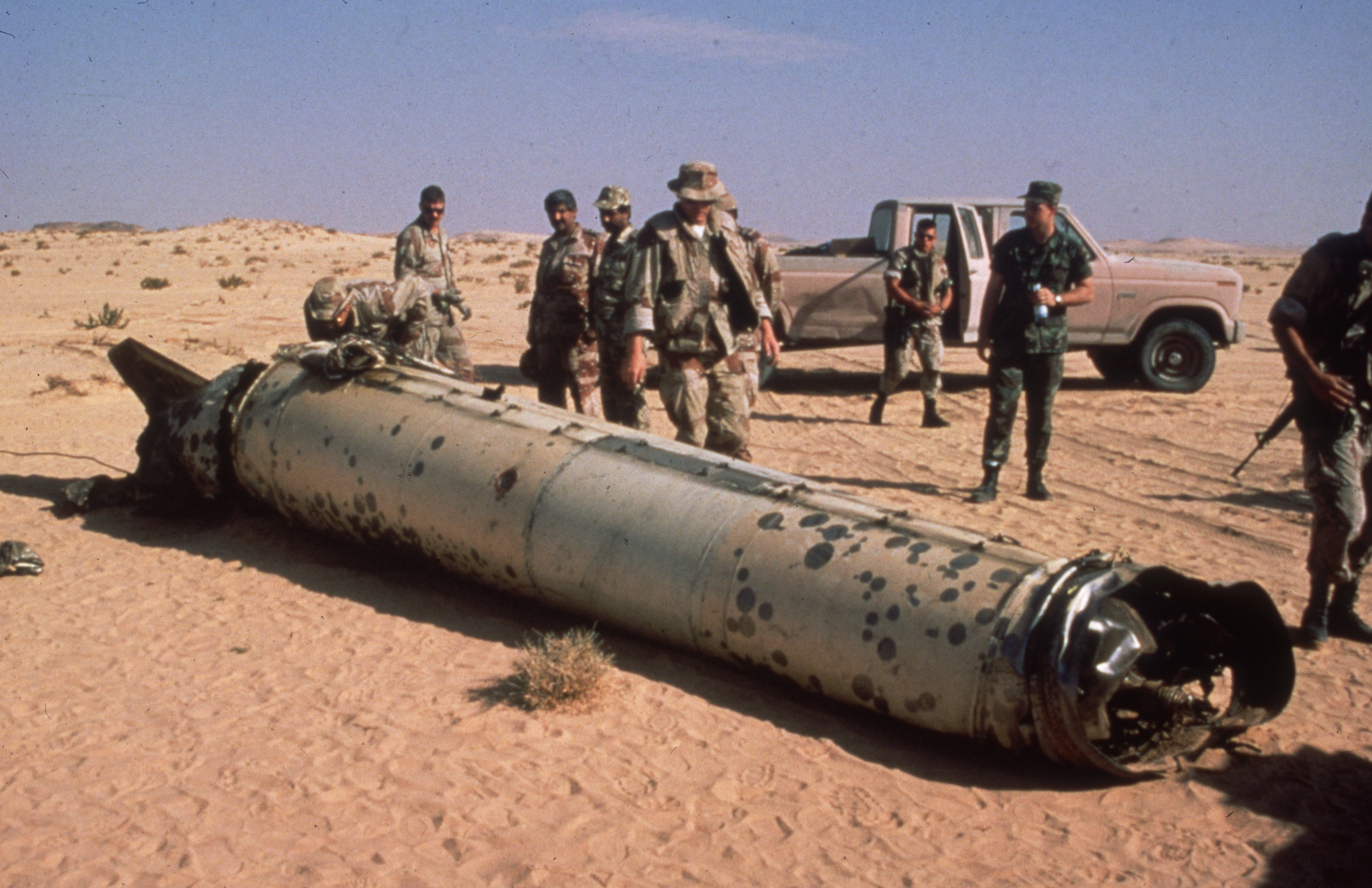 1991: Allied troops stand around the remains of an Iraqi Scud missile lying in the desert during Operation Desert Storm, Persian Gulf War. The Iraqis attacked Israeli and Saudi Arabian sites with the missiles. (Photo by Consolidated News Pictures/Getty Images)