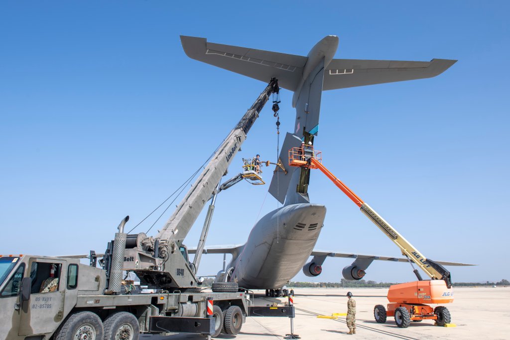 NAVAL STATION ROTA, Spain (Feb. 22, 2023) Seabees assigned to Naval Mobile Construction Battalion (NMCB) 1, NMCB 11, and Air Force Personnel from the 436th Maintenance Squadron (MXS), install a new tail rudder on a C5 Super Galaxy. This maintenance evolution is the first time it had been completed outside of Dover Air Force Base. NMCB 1 operates as a part of Navy Expeditionary Combat Command and is assigned to Commander, Task Force 68 for deployment across the U.S. Naval Forces Europe-Africa area of operations to defend U.S., allied, and partner interests. (U.S. Navy photo by Mass Communication Specialist 1st Class Sean P. Rinner)