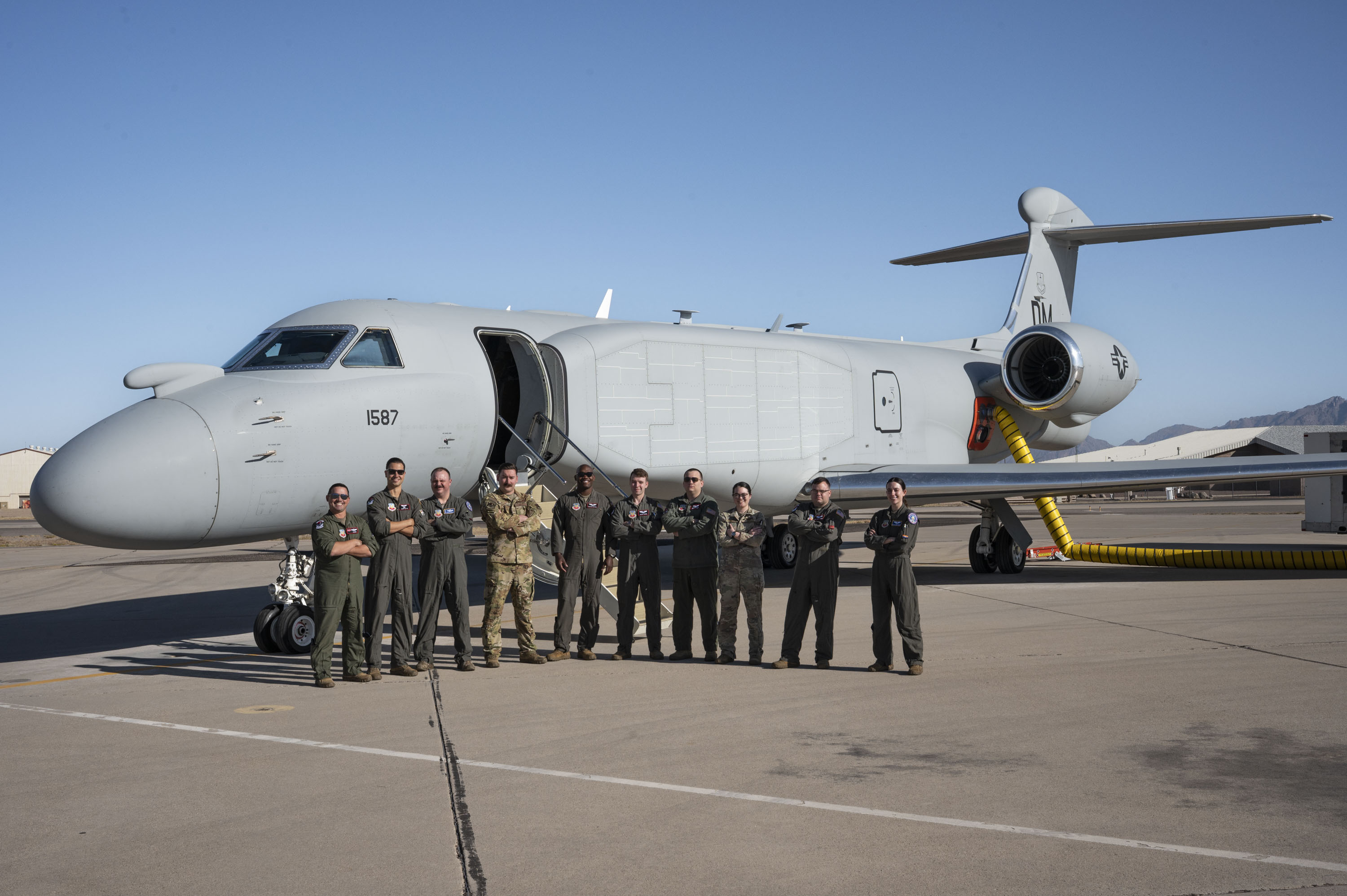 U.S. Airmen assigned to the 43rd Electronic Combat Squadron pose for a group photo before boarding the EA-37B Compass Call aircraft for its first official mission training sortie flight at Davis-Monthan Air Force Base, Arizona, May 2, 2025. The EA-37B sustains Joint Force military advantage in the electromagnetic battlespace and builds a more lethal force by modernizing electromagnetic attack capabilities to deny peer competitors' tactical networks and information ecosystems. (U.S. Air Force photo by Airman Samantha Melecio)