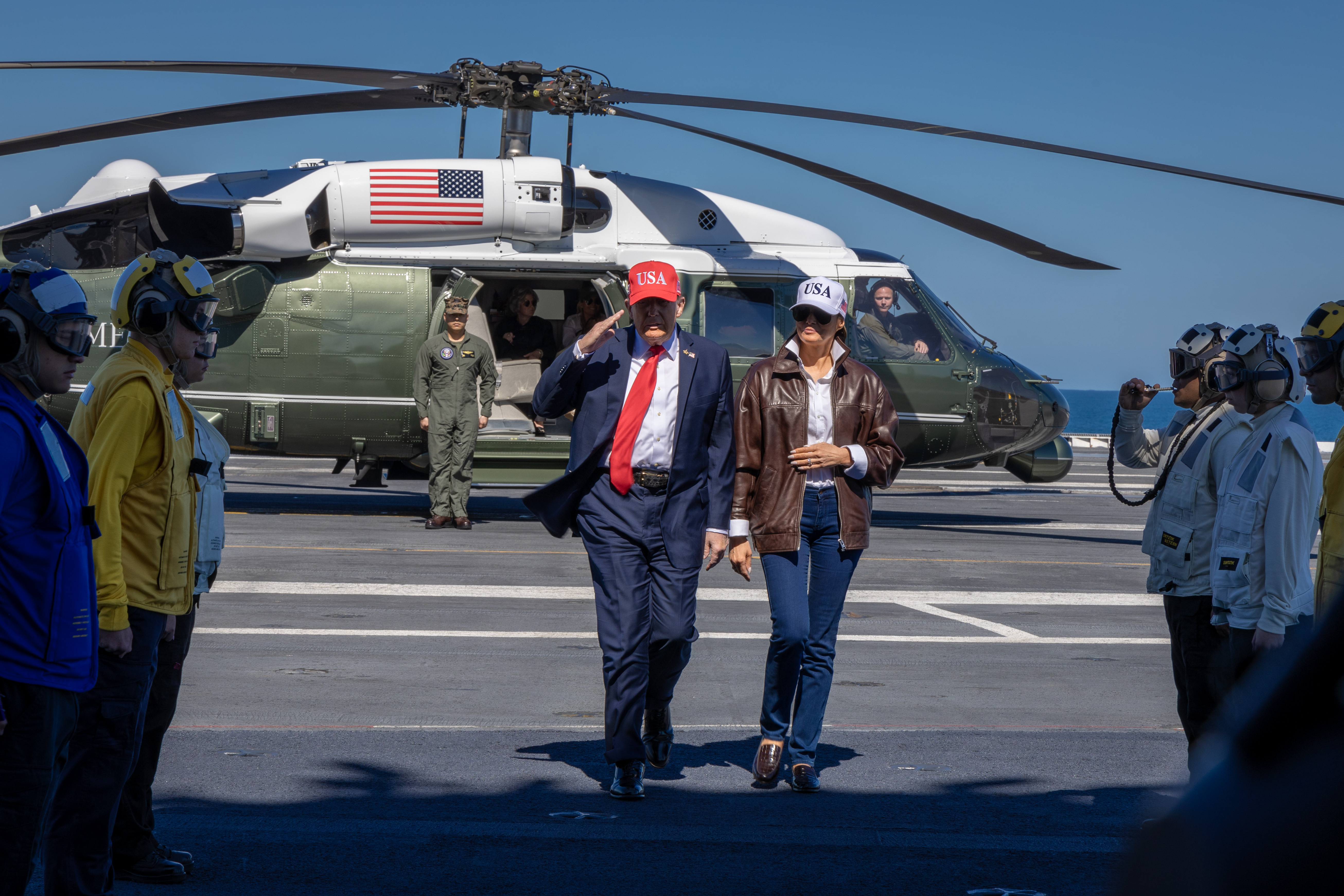 251005-N-SK738-1090 ATLANTIC OCEAN (Oct. 5, 2025) President Donald J. Trump and First Lady Melania Trump receive honors from rainbow sideboys aboard the Nimitz-class aircraft carrier USS George H. W. Bush (CVN 77) during a Titans of the Sea Presidential Review Oct. 5, 2025. The Titans of the Sea Presidential Review is one of many events taking place throughout the country to showcase maritime capabilities as part of the U.S. Navy’s 250th birthday. America is a maritime nation. For 250 years, America’s Warfighting Navy has sailed the globe in defense of freedom. (U.S. Navy photo by Mass Communication Specialist 2nd Class Pierce Luck)