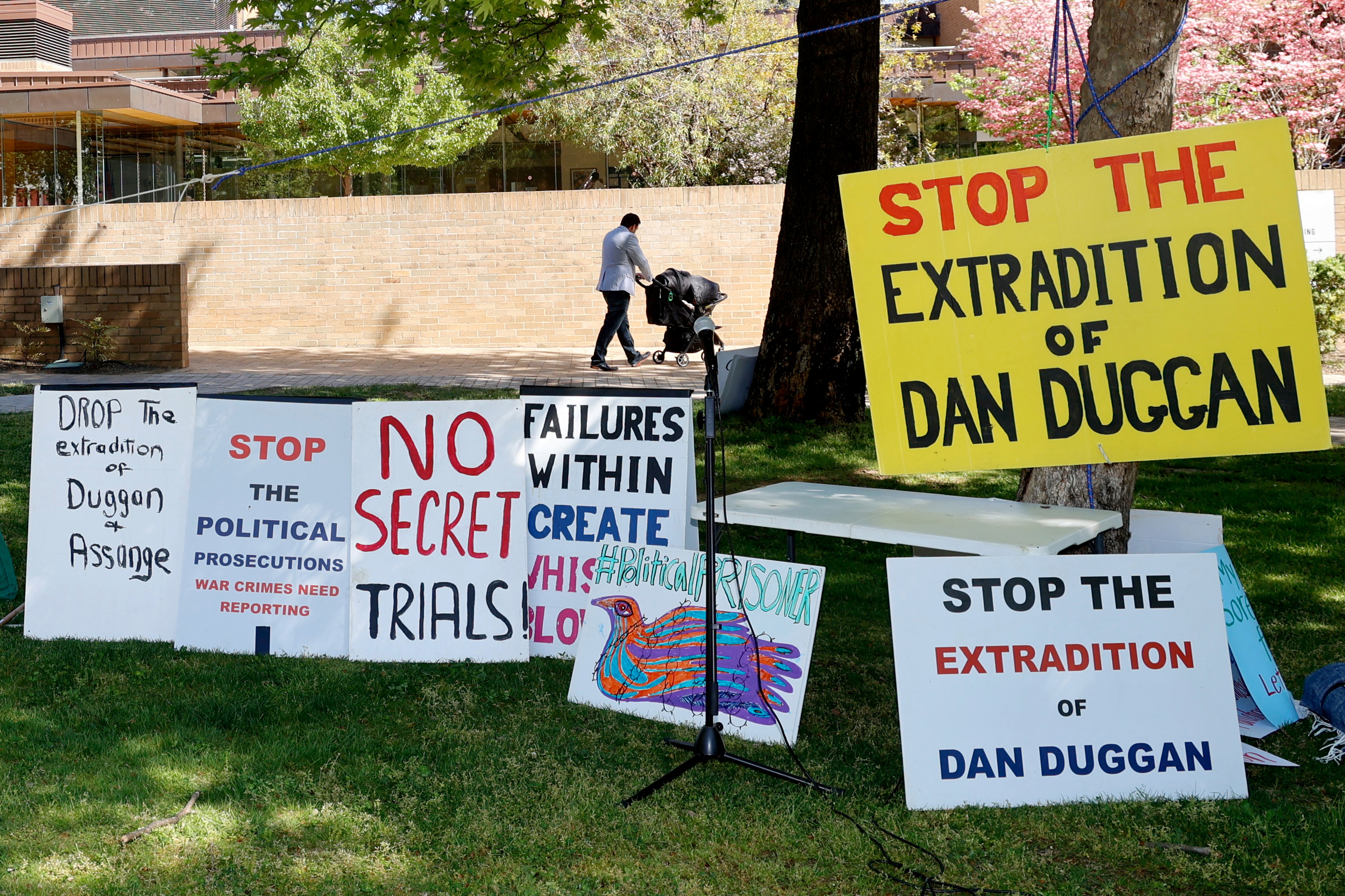 Placards placed by supporters of Daniel Edmund Duggan are displayed outside the Federal Court of Australia in Canberra on October 16, 2025. Daniel Edmund Duggan, an ex-US Marine pilot accused of illegally training China's military, was arrested in Australia in October 2022 at the request of the US government, which accuses him of breaking arms control laws. It alleges he illegally trained Chinese military pilots between 2010 and 2012, after he left the Marines. Duggan has denied the charges. (Photo by Hilary WARDAUGH / AFP) (Photo by HILARY WARDAUGH/AFP via Getty Images)