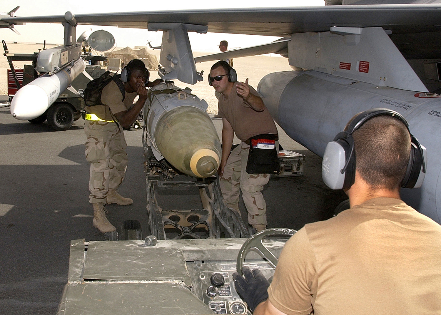 OPERATION IRAQI FREEDOM -- A weapons load crew from the 22nd Expeditionary Fighter Squadron loads a GBU-31 precision-guided bomb on an F-16 Fighting Falcon on March 24 at a forward-deployed Operation Iraqi Freedom air base. (U.S. Air Force photo by Staff Sgt. Derrick C. Goode)