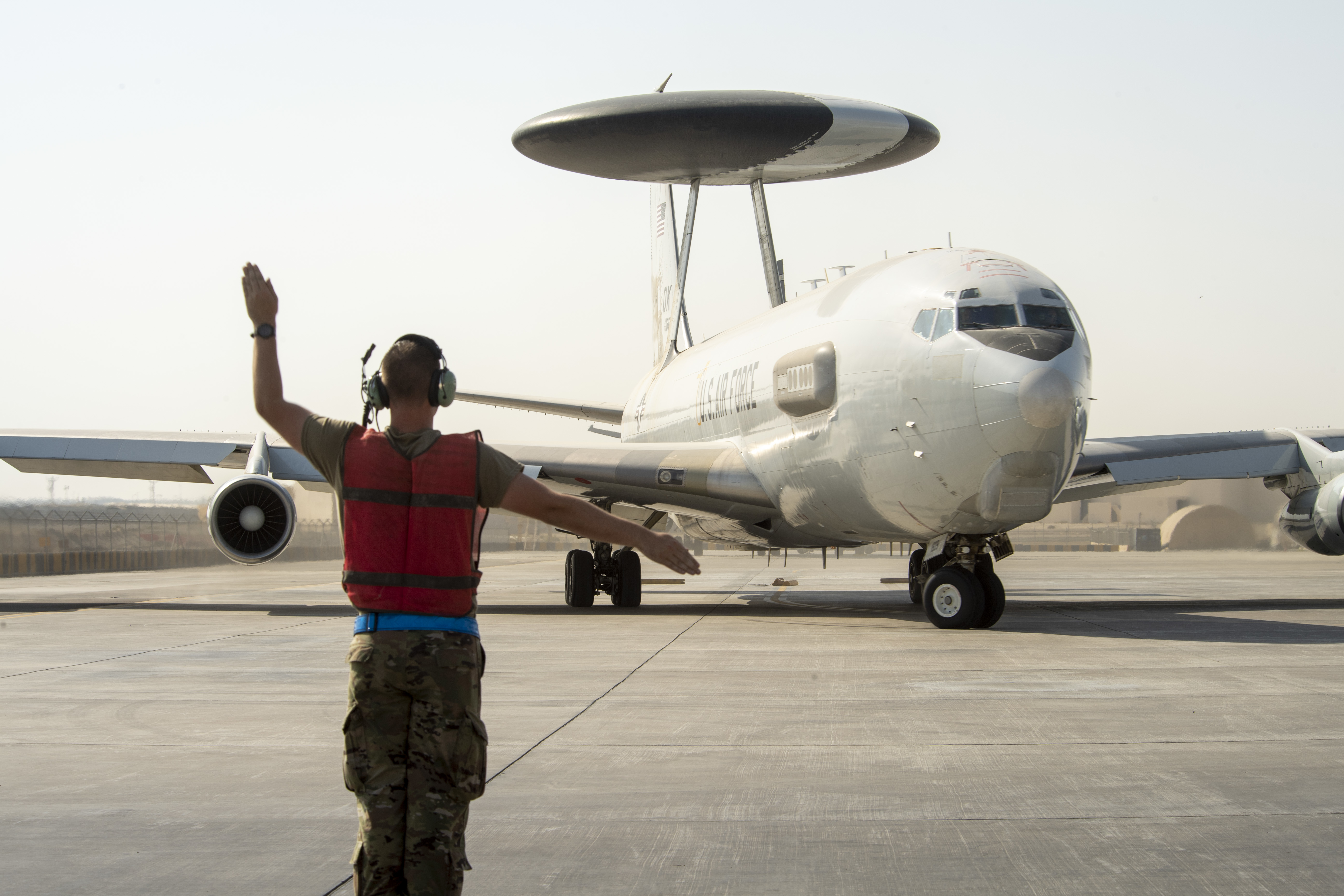 U.S. Air Force Senior Airman Stephen Baker, an E-3 Sentry crew chief, 380th Expeditionary Aircraft Maintenance Squadron, marshals a U.S. Air Force E-3 Sentry Airborne Warning and Control System (AWACS) aircraft on Al Dhafra Air Base, United Arab Emirates, May 19, 2021. The E-3 crew participated in Desert Mirage III – the third iteration of a bilateral event designed to enhance the interoperability and air defense capabilities between partner nation forces in the region. The AWACS delivered all-weather surveillance and direct information needed for interdiction, reconnaissance, airlift, and close-air support to joint and Royal Saudi Air Forces aircraft during the training. (U.S. Air Force photo by Master Sgt. Wolfram M. Stumpf)