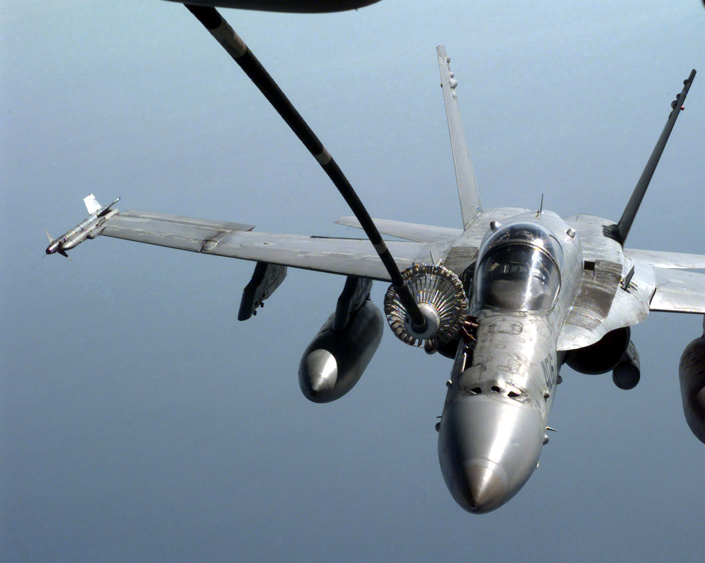 A US Navy (USN) F/A-18C Hornet armed with an AIM-9 Sidewinder, from Fighter Attack Squadron One Ninetly-Five (VFA-195) refuels over the Persian Gulf, in support of Operation SOUTHERN WATCH 1998.
