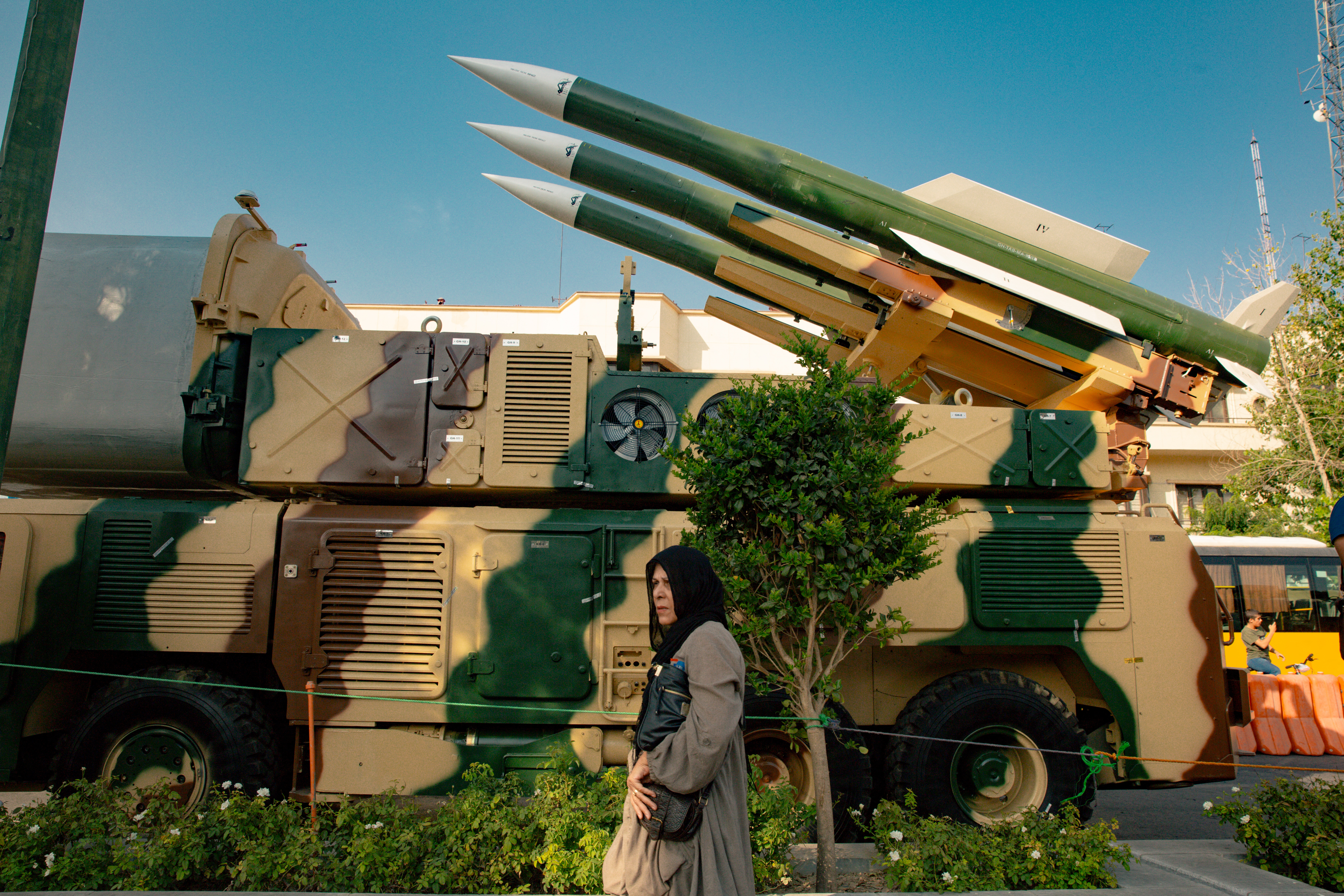 An Iranian woman passes by a Russian-made Sam-6 surface-to-air missiles is displayed at a war exhibition held by Iran's Revolutionary Guard Corps to mark the anniversary of the Iran-Iraq war (1980-88), also known in Iran as the "Holy Defence", at Baharestan square near the Iranian Parliament in southern Tehran. (Photo by Khoshiran / Middle East Images / Middle East Images via AFP) (Photo by KHOSHIRAN/Middle East Images/AFP via Getty Images)