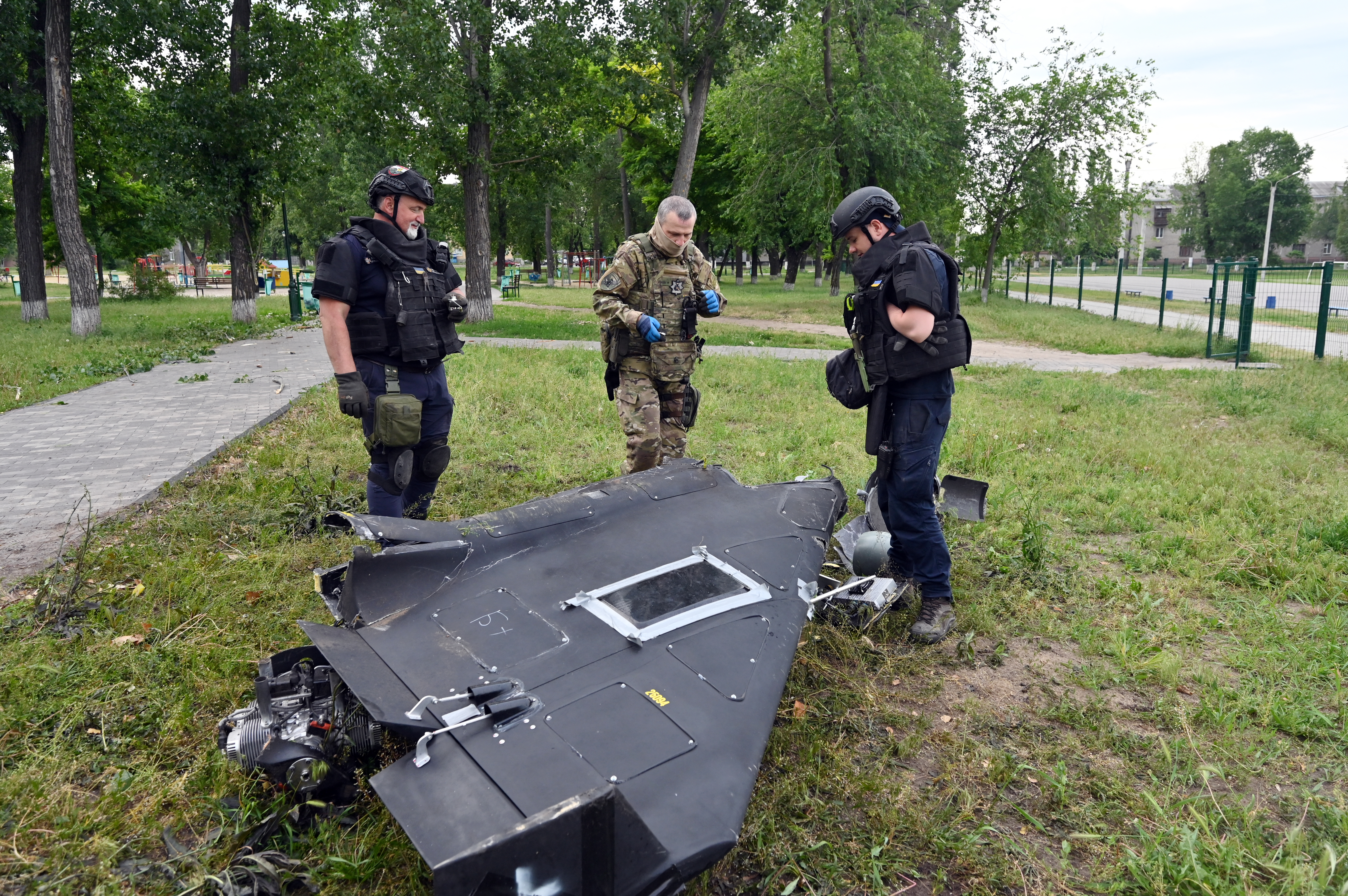 Ukrainian explosives experts and police officers examine parts of a Shahed 136 military drone following an air-attack in Kharkiv on June 4, 2025, amid the Russian invasion of Ukraine. (Photo by SERGEY BOBOK / AFP via Getty Images)