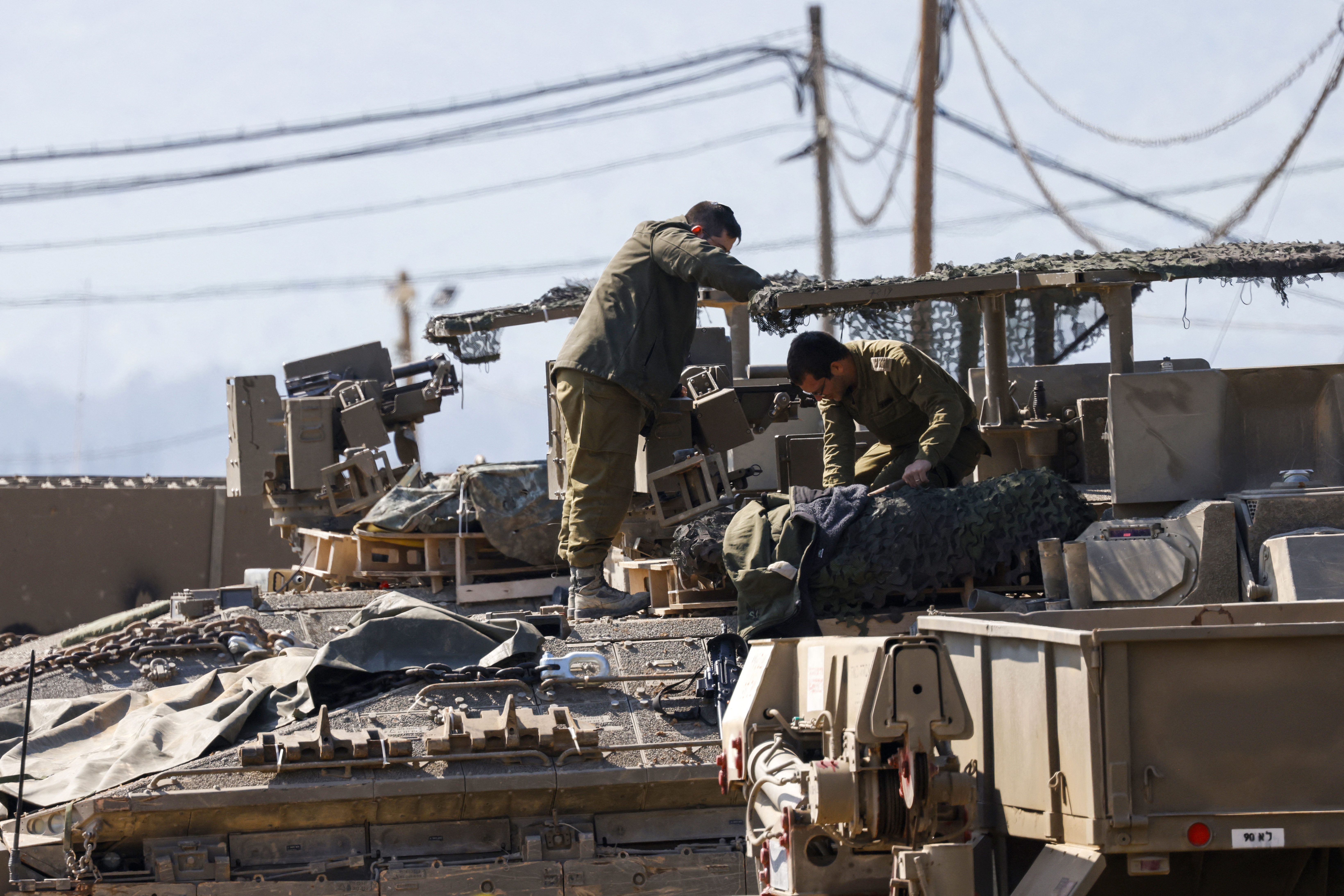 Israeli soldiers arrange their equipment on top of a tank in the Upper Galilee near the Lebanon border on March 2, 2026. Israel bombarded Lebanon on March 2 following rocket fire from Hezbollah, several American warplanes crashed in Kuwait and Iran lashed out against the region with missiles, as the war with Israel and the United States expanded. (Photo by Jalaa MAREY / AFP via Getty Images)