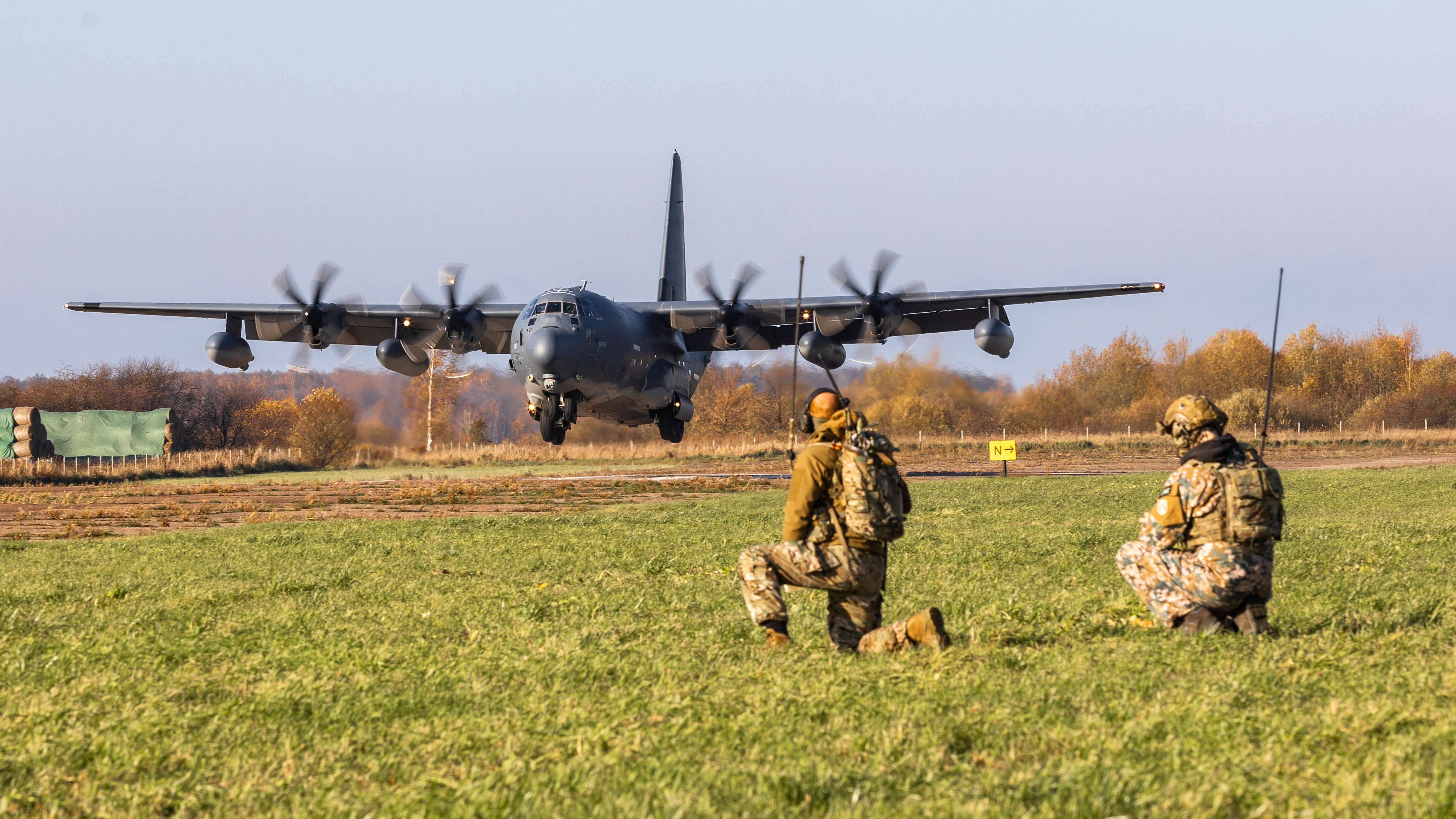 A Latvian Special Operations Unit Joint Terminal Attack Controller (JTAC) and U.S. Air Force Special Forces Combat Controller guide an incoming MC-130J Commando II assigned with the 352nd Special Operations Wing as part of a bilateral exercise in Riga, Latvia October, 25 2021. The aircraft was transporting a platoon in charge of the Wisconsin Army National Guard’s High Mobility Artillery Rocket System (HIMARS) demonstrating the rapid, ready response capabilities that special operations enable for conventional forces in austere environments. (U.S. Army Photo by Sgt. Patrik Orcutt)