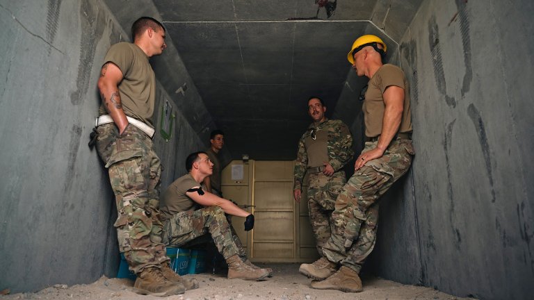 Airmen from the 386th Air Expeditionary Wing sit inside of a bunker during a base-wide exercise at an undisclosed location within the U.S. Central Command area of responsibility, May 24, 2024. The exercise assessed the responsiveness of Airmen and first responders during a simulated attack. (U.S. Air Force photo)